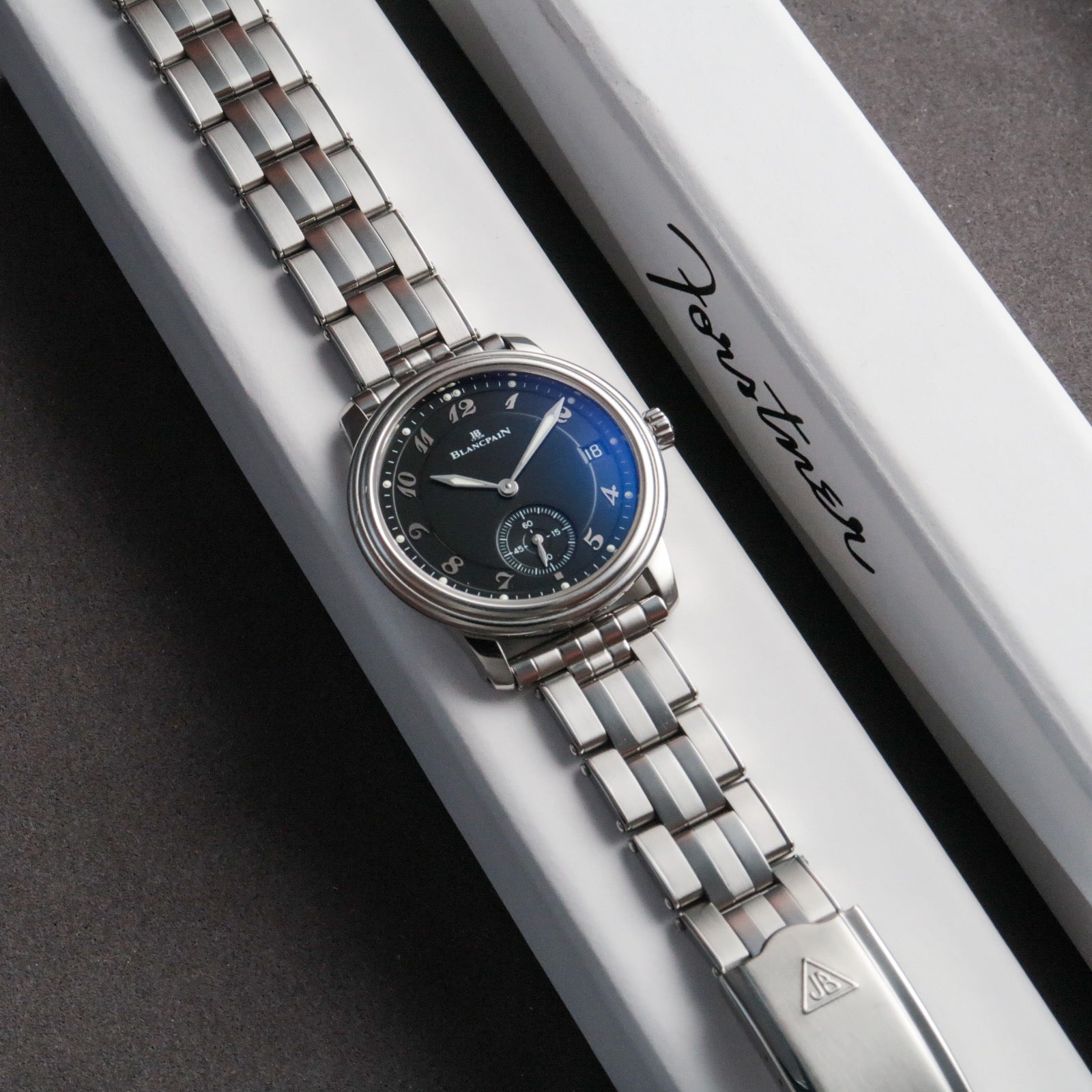 Blancpain luxury watch with blue sunburst dial and steel 5-link bracelet on branded presentation box