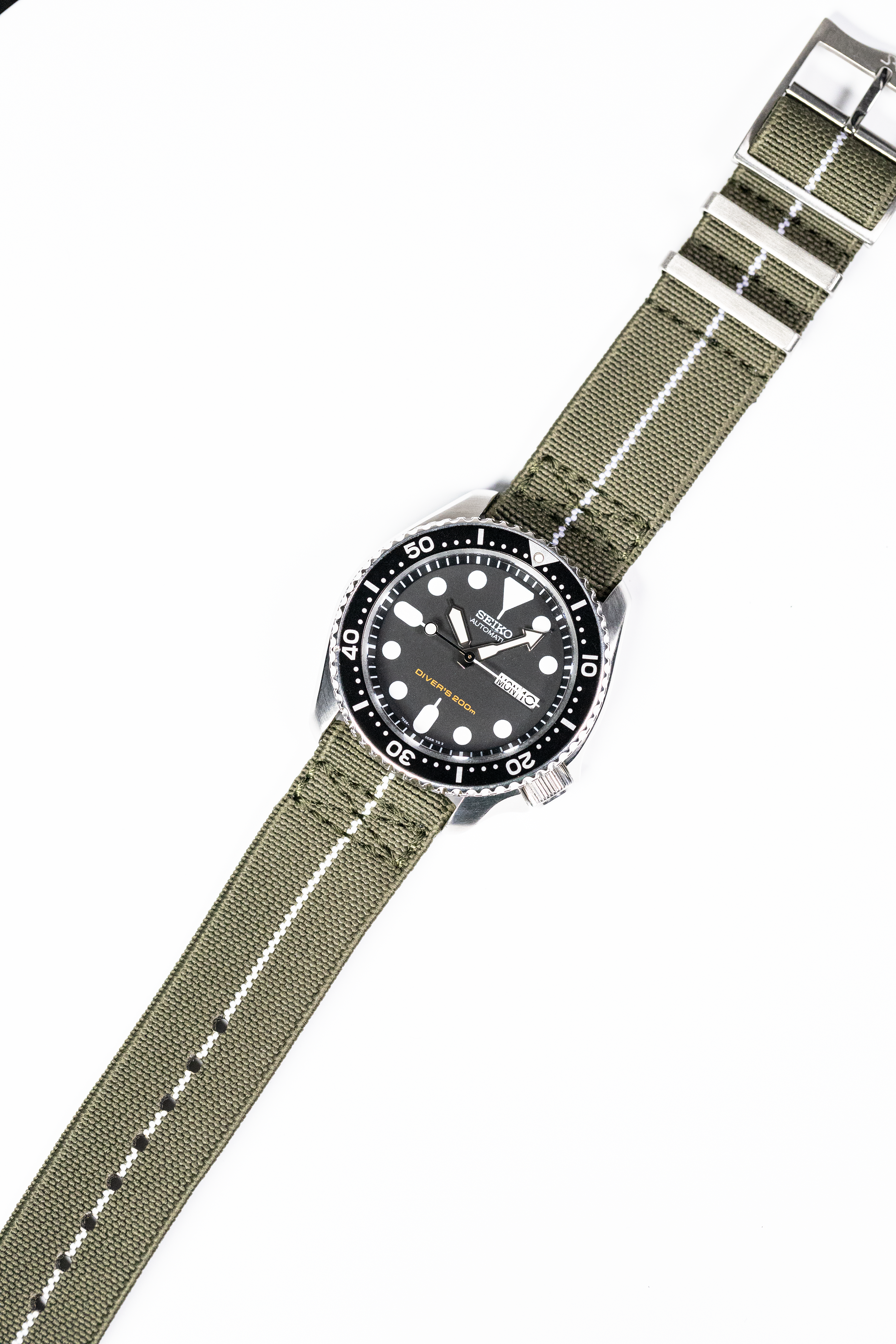 Seiko automatic diver watch with black dial and olive green fabric strap with white stripe