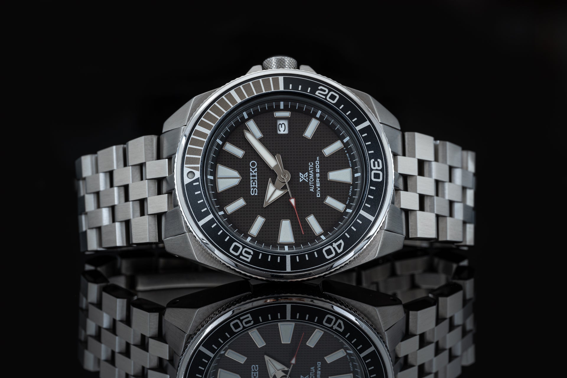 Seiko Prospex Samurai automatic diver watch with stainless steel bracelet and black dial on black background