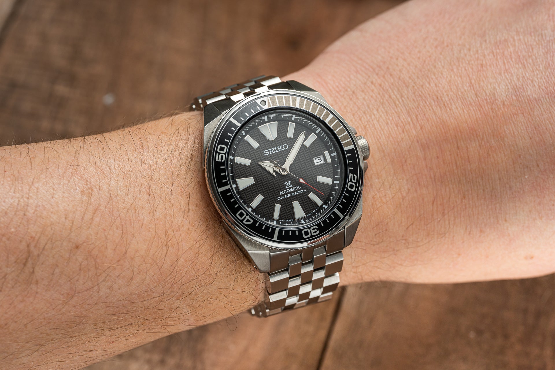 Seiko Samurai automatic dive watch with stainless steel bracelet and black dial on wrist