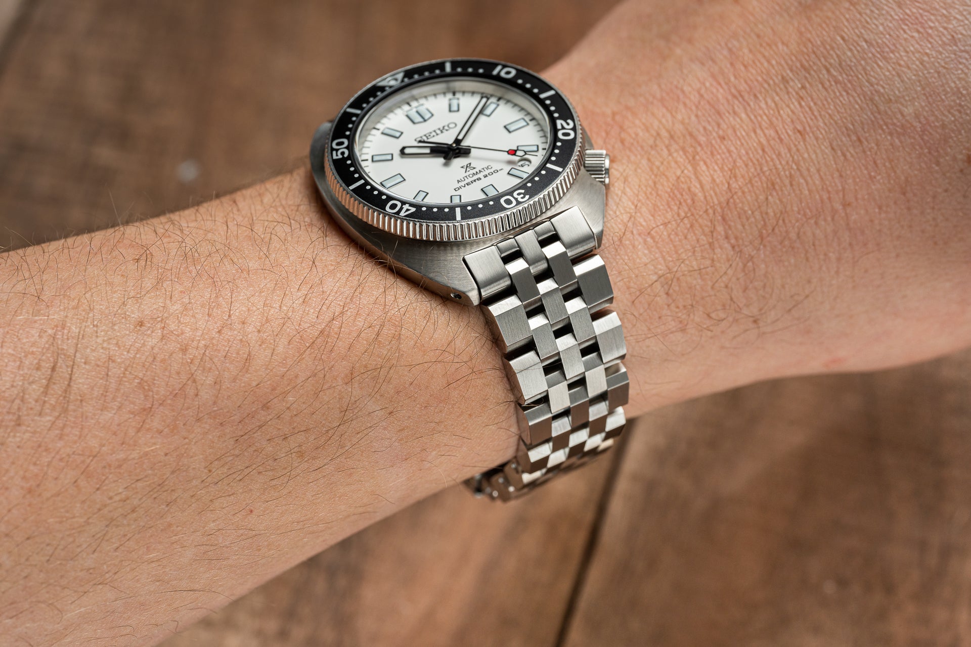 Seiko SPB317 Slim Turtle dive watch with white dial and black bezel on stainless steel jubilee bracelet worn on wrist