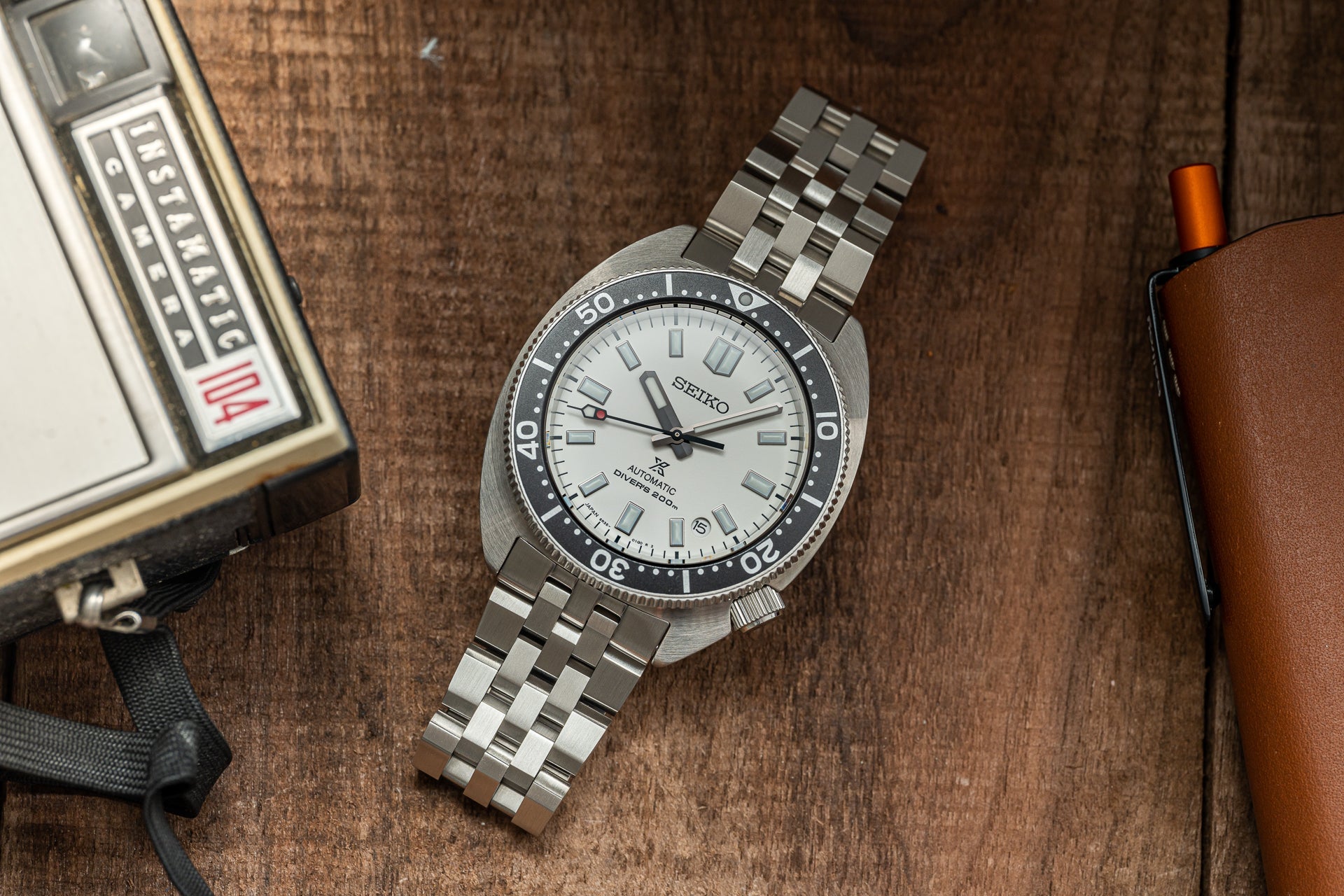 Seiko SPB317 Slim Turtle automatic dive watch with stainless steel bracelet and white dial on wooden surface