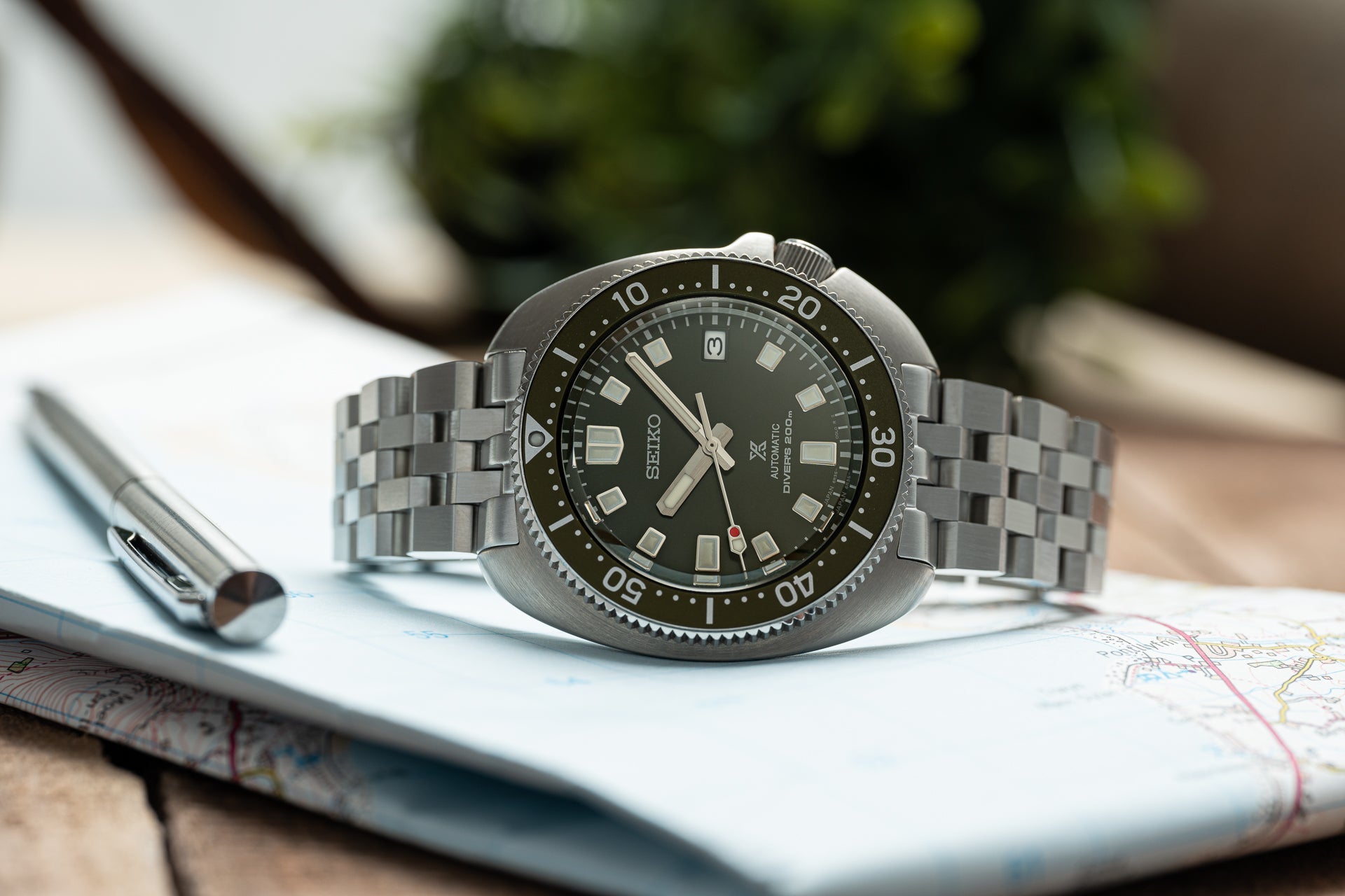 Seiko Super Engineer automatic diving watch with black dial, stainless steel bracelet and bezel on map background