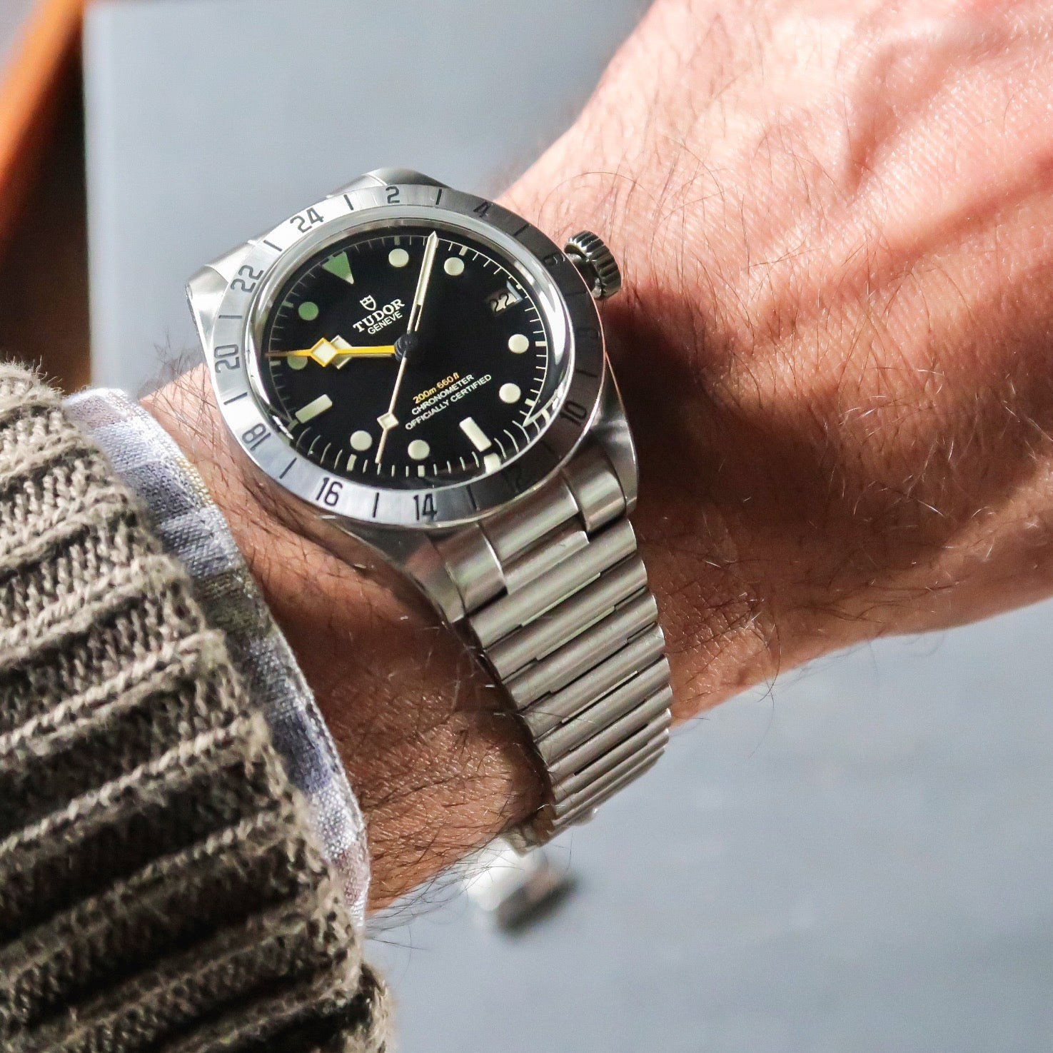Tudor Black Bay Pro dive watch with stainless steel barrel bracelet worn on wrist, black dial with luminous markers and rotating bezel