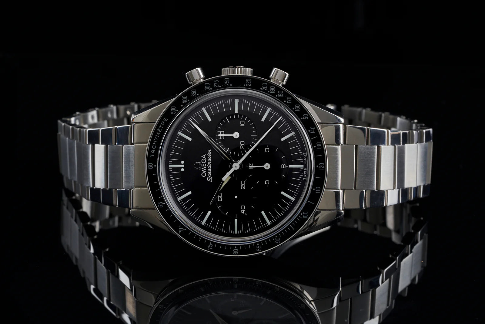 Omega Speedmaster chronograph watch with black dial, tachymeter bezel, and stainless steel bracelet on black background