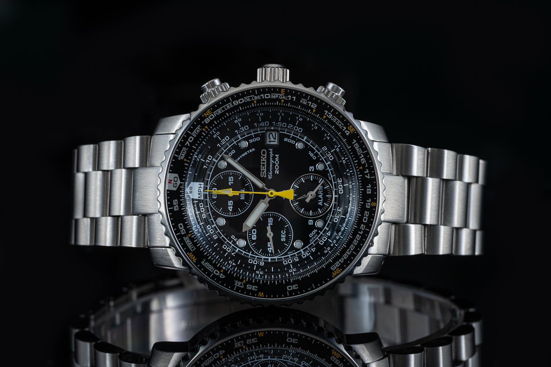 Seiko SNA411 Flightmaster chronograph watch with stainless steel bracelet, black dial, yellow hands, and multiple subdials on black background