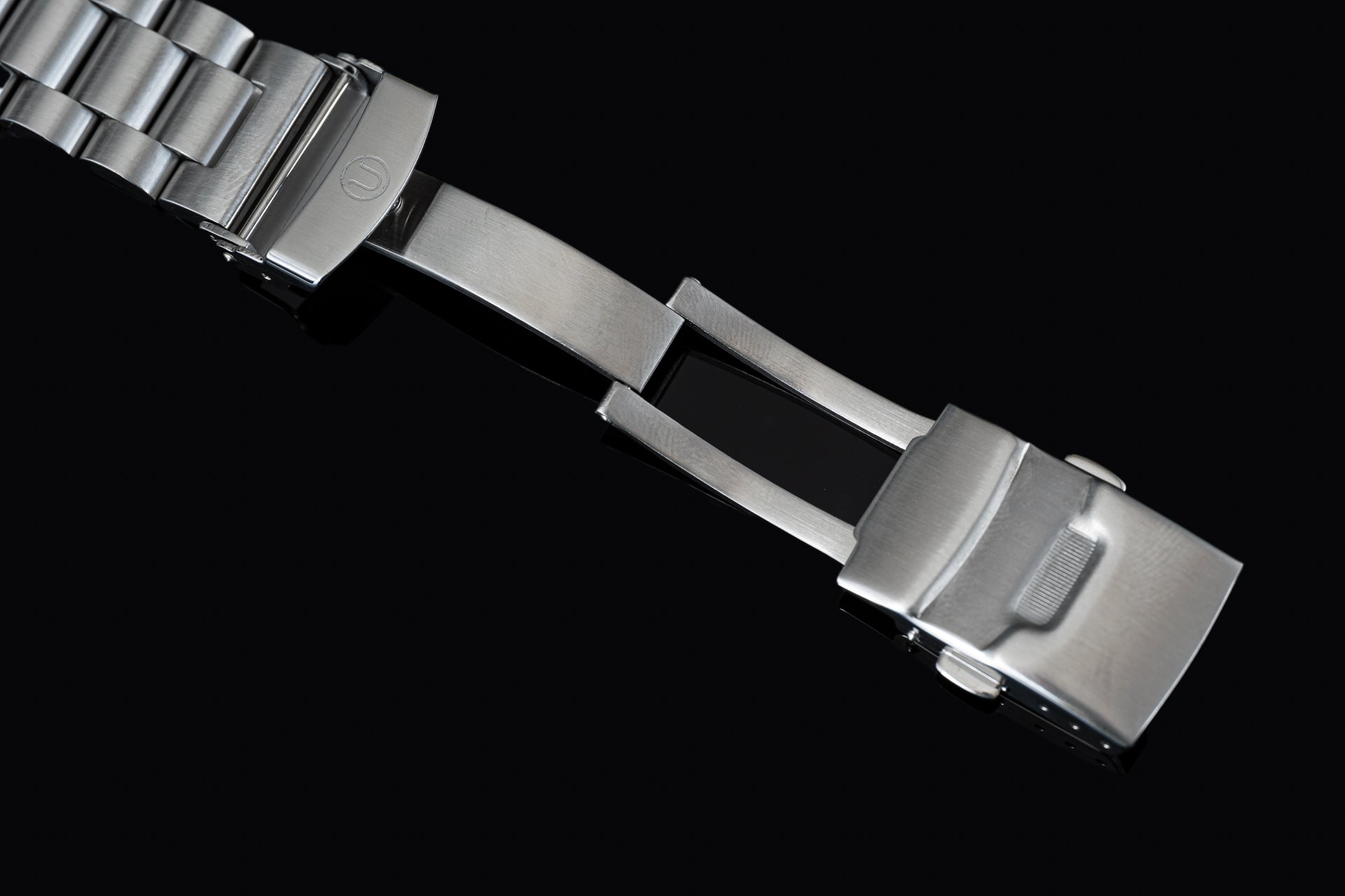 Stainless steel Seiko SNA411 Flightmaster chronograph watch bracelet with polished end links and brushed center links on black background
