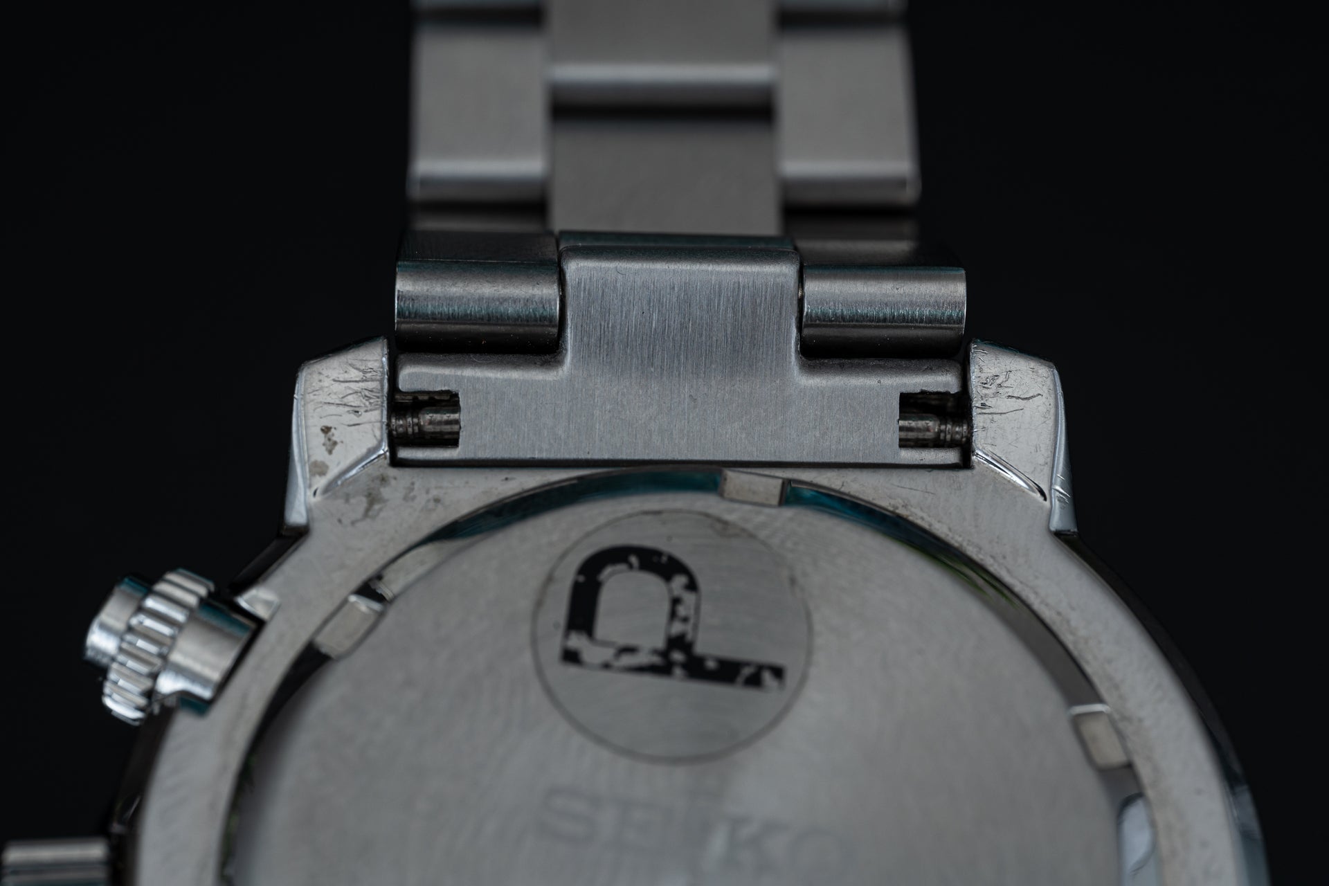 Stainless steel Seiko Flightmaster chronograph watch with solid metal bracelet, top-down view showing case back and hinged lugs