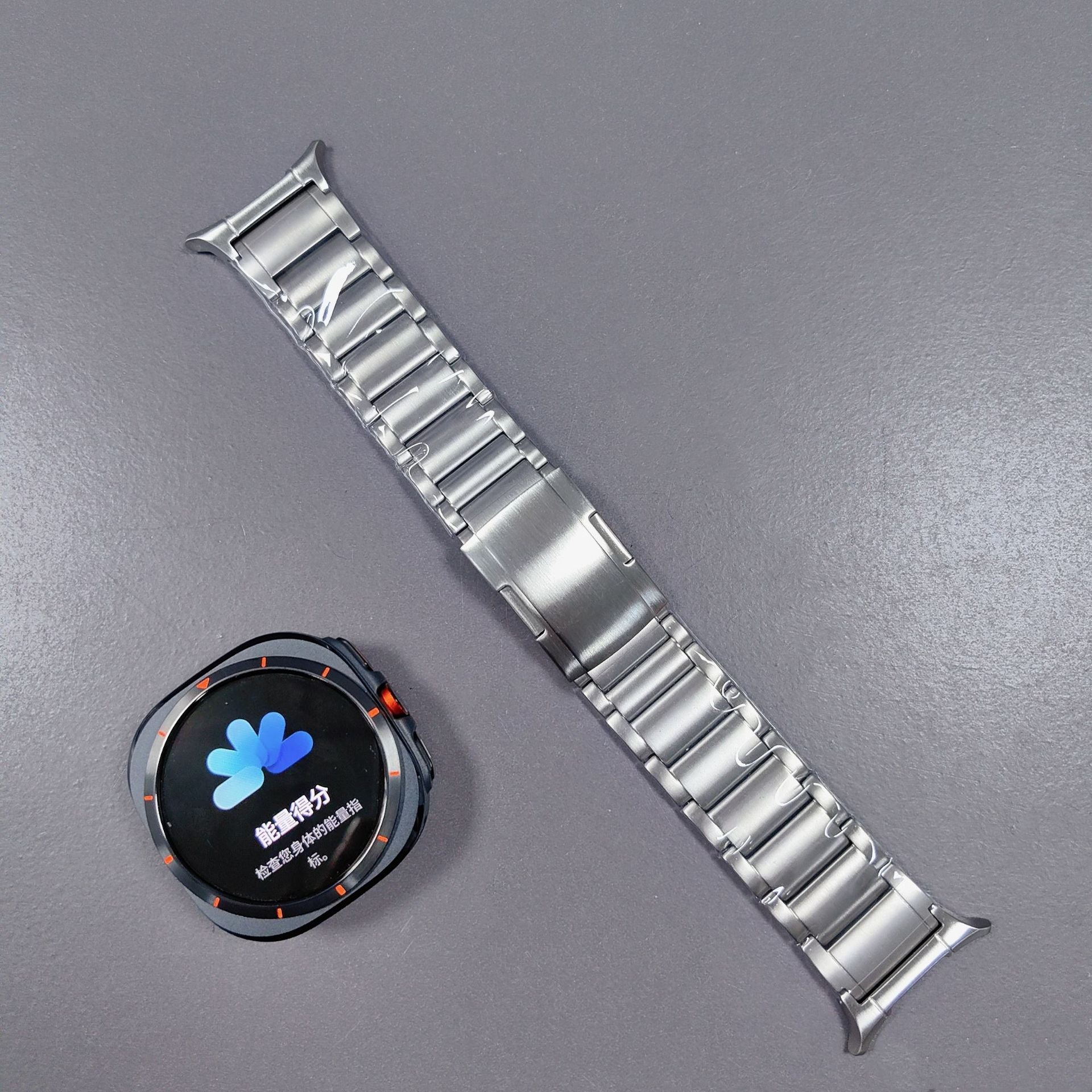 Stainless steel link bracelet with connector for Galaxy Watch Ultra smartwatch on gray background