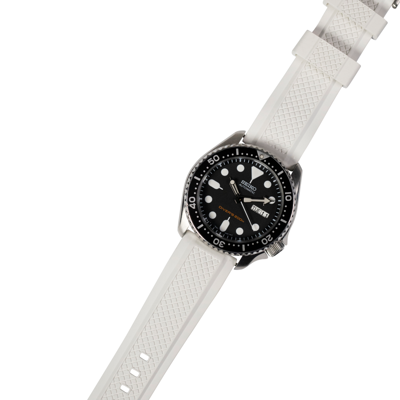 Seiko diver watch with black dial and white rubber strap, featuring rotating bezel and day-date window