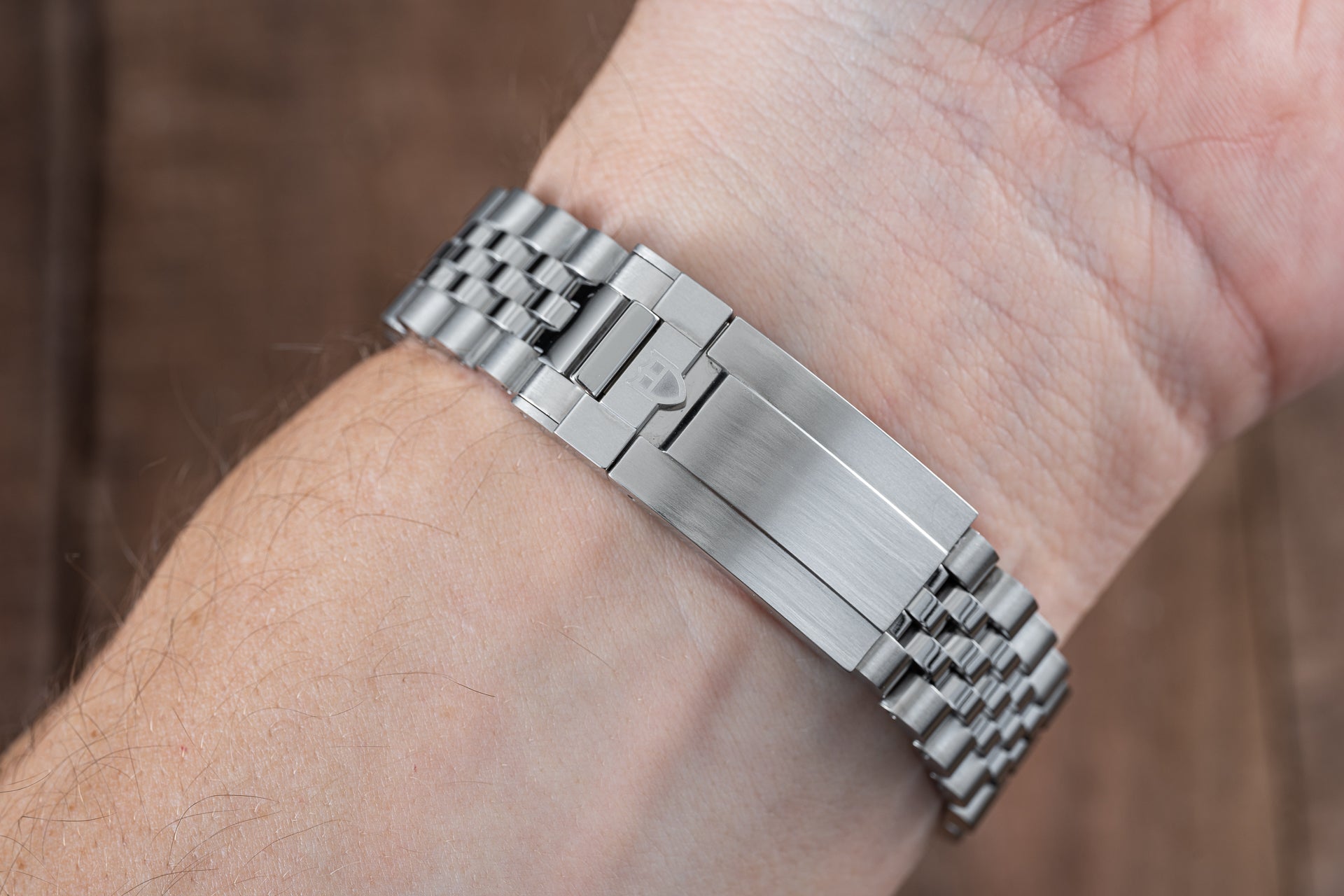 Stainless steel watch bracelet with solid link construction and brushed finish, worn on wrist with Tudor Black Bay Pro compatibility