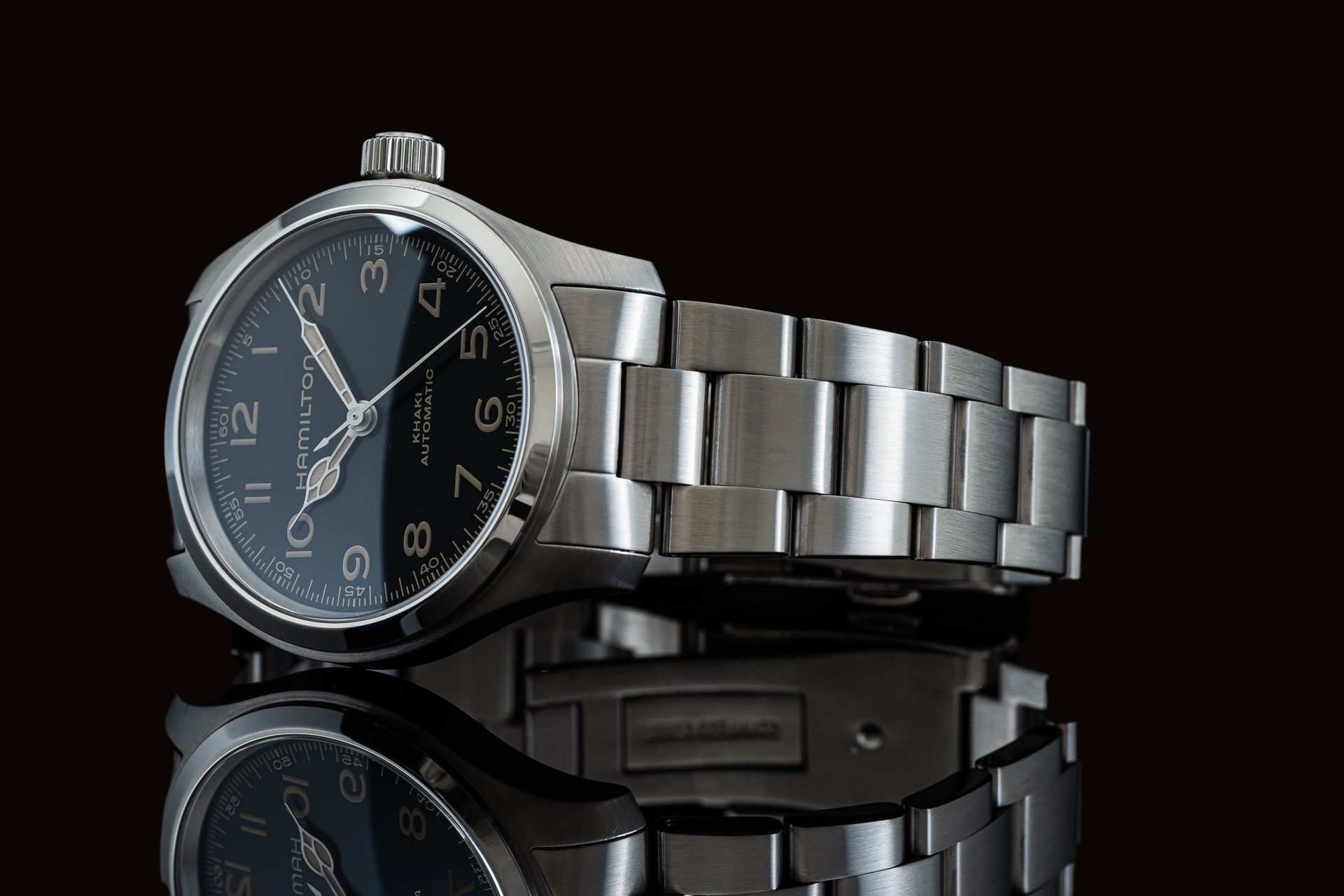 Hamilton Khaki Aviation automatic watch with dark dial and stainless steel bracelet on black background