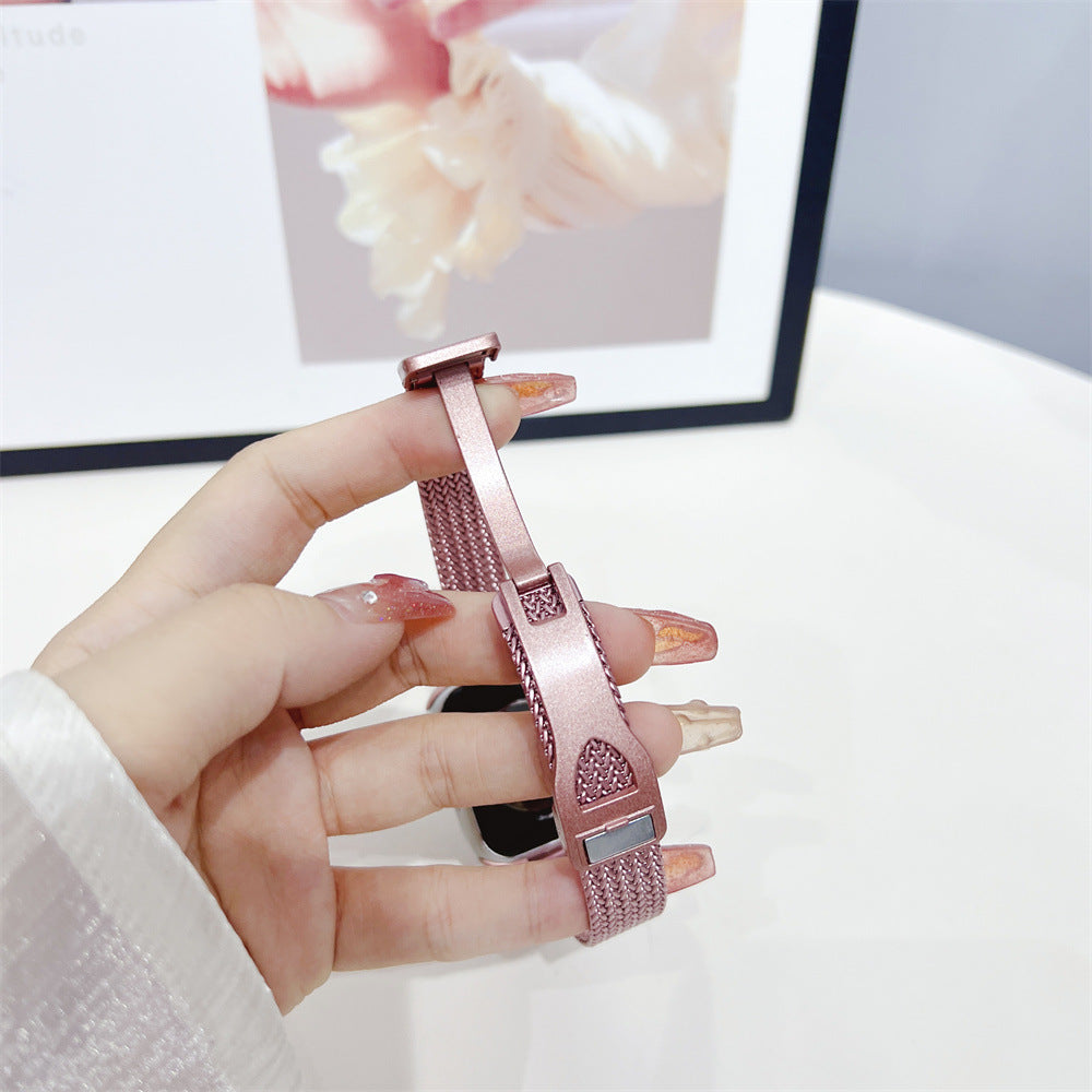 Rose gold herringbone mesh smartwatch band with decorative charm held in hand, displayed against digital screen background