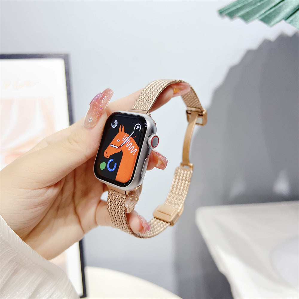 Apple Watch with herringbone mesh bracelet in rose gold, displayed in hand showing orange watch face interface
