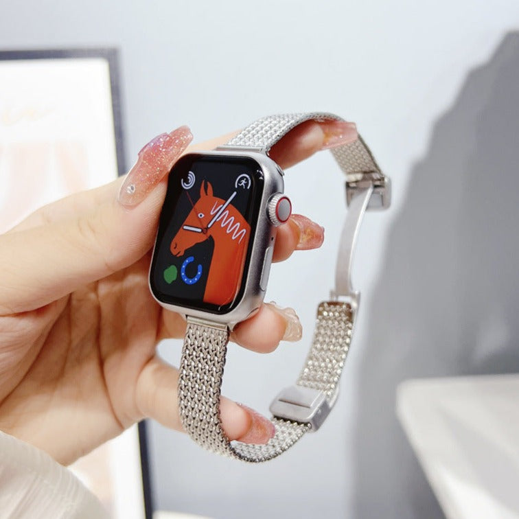 Stainless steel herringbone mesh bracelet for Apple Watch with silver band and magnetic clasp, displayed on wrist