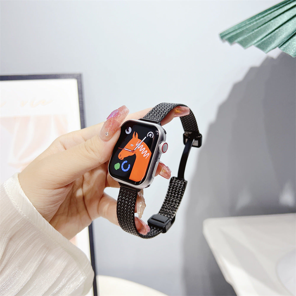 Smartwatch with orange watch face displayed on wrist wearing black herringbone mesh metal bracelet band