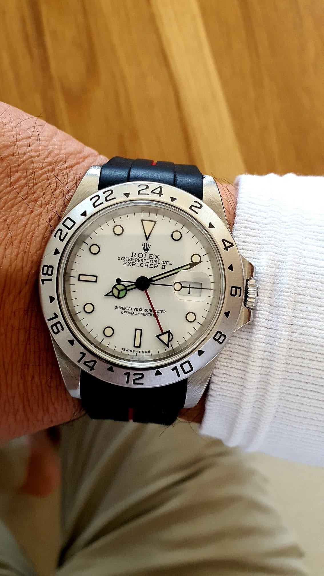 Rolex Explorer II stainless steel watch with white dial, GMT hand, black rubber strap, and 24-hour bezel on wrist