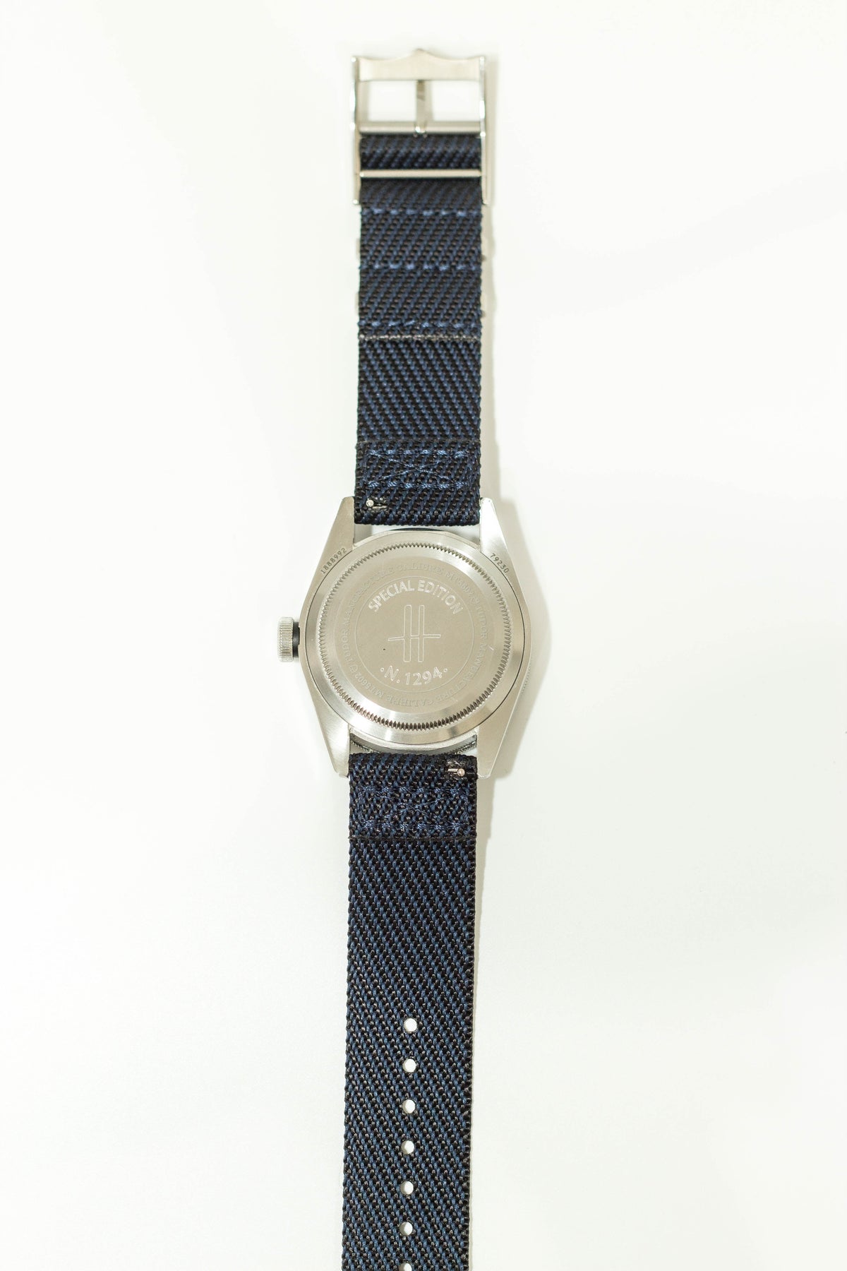Silver-tone watch with blue woven fabric strap and special edition engraved case back