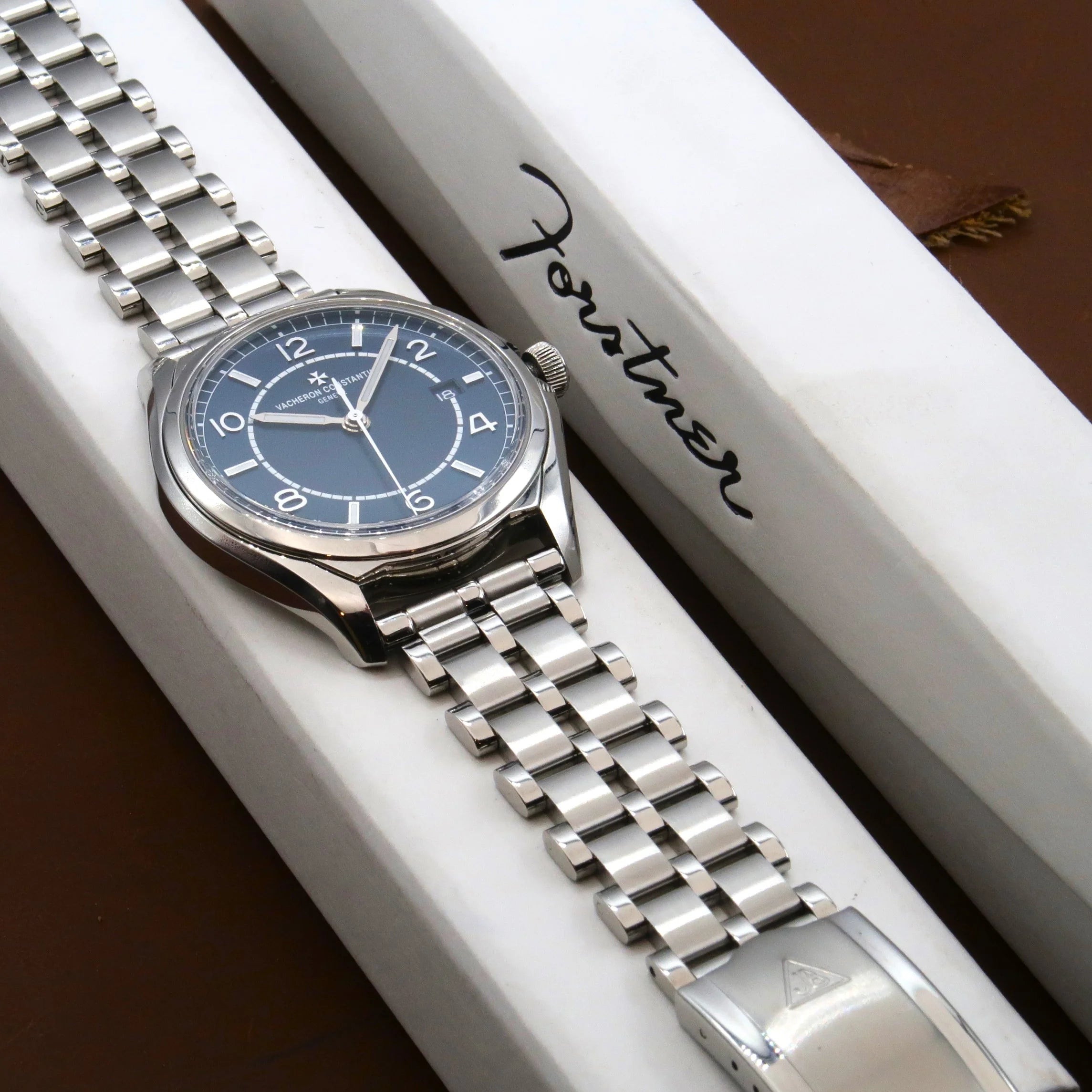 Stainless steel watch with blue dial and five-row beads of rice bracelet displayed in white branded box