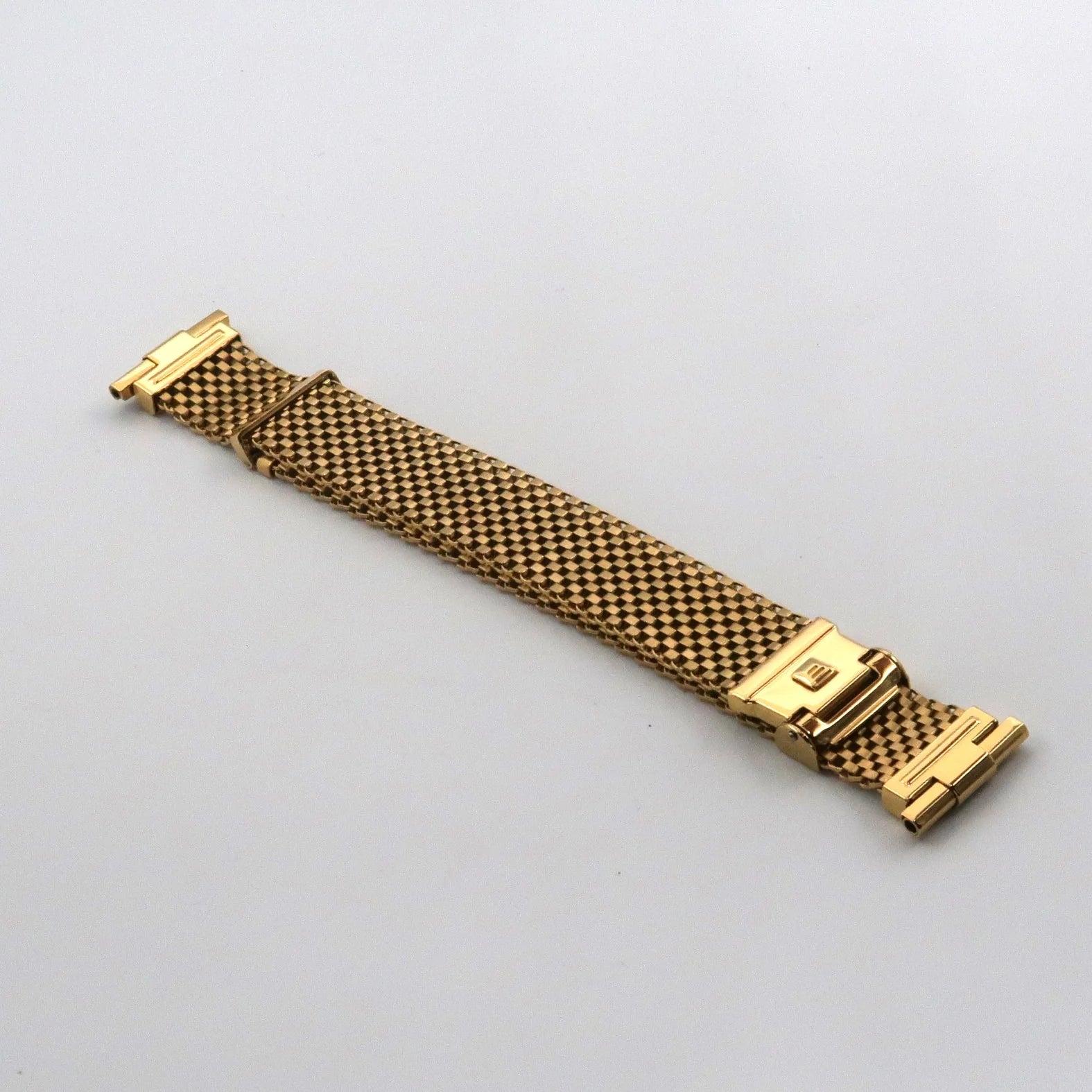 Gold plated mesh watch bracelet with straight ends and fold-over clasp on white background
