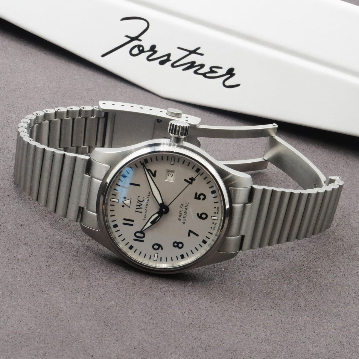 IWC Mark XX stainless steel automatic watch with barrel link bracelet and cream dial on gray surface