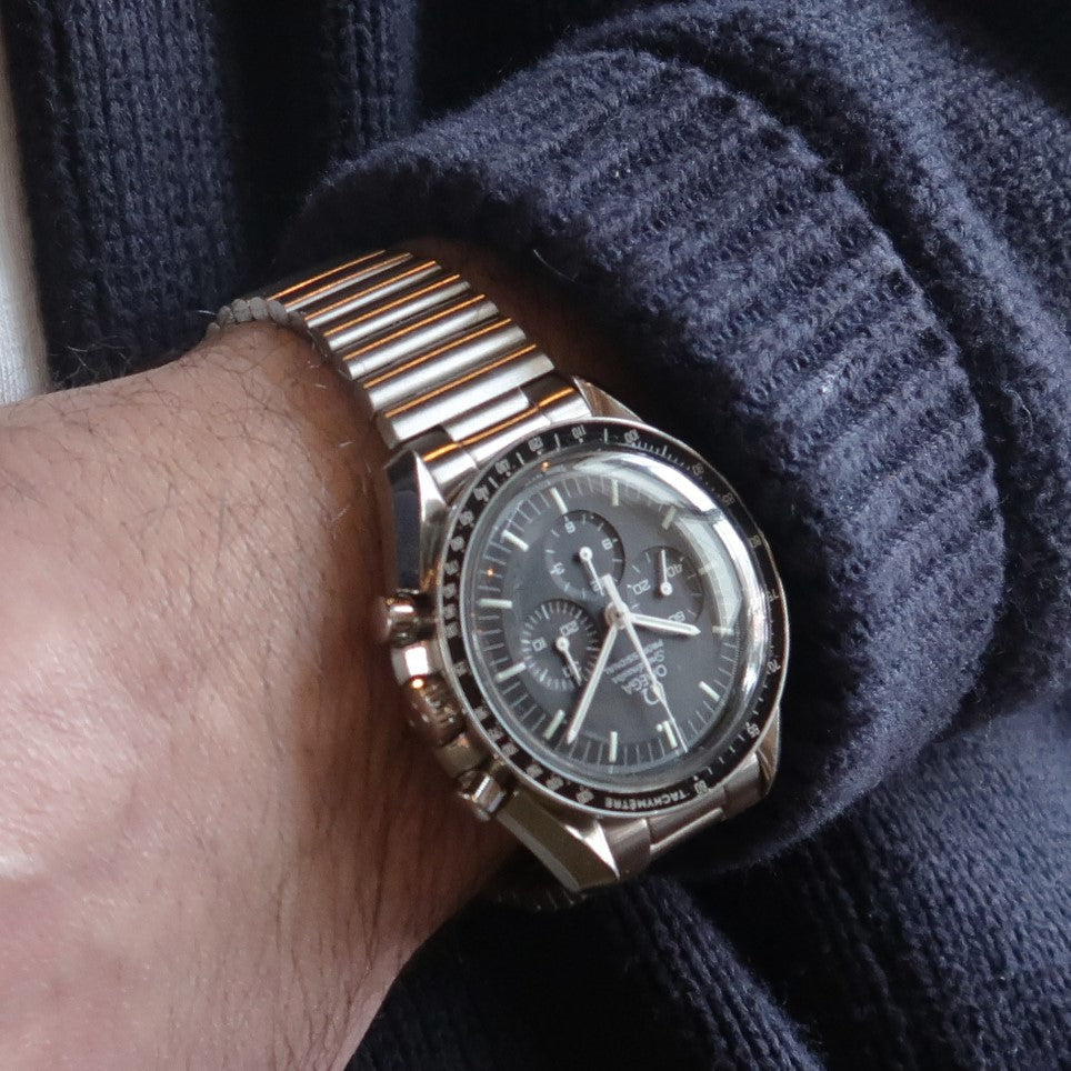 Stainless steel Forstner barrel bracelet on Omega Speedmaster chronograph watch worn with dark knit sweater