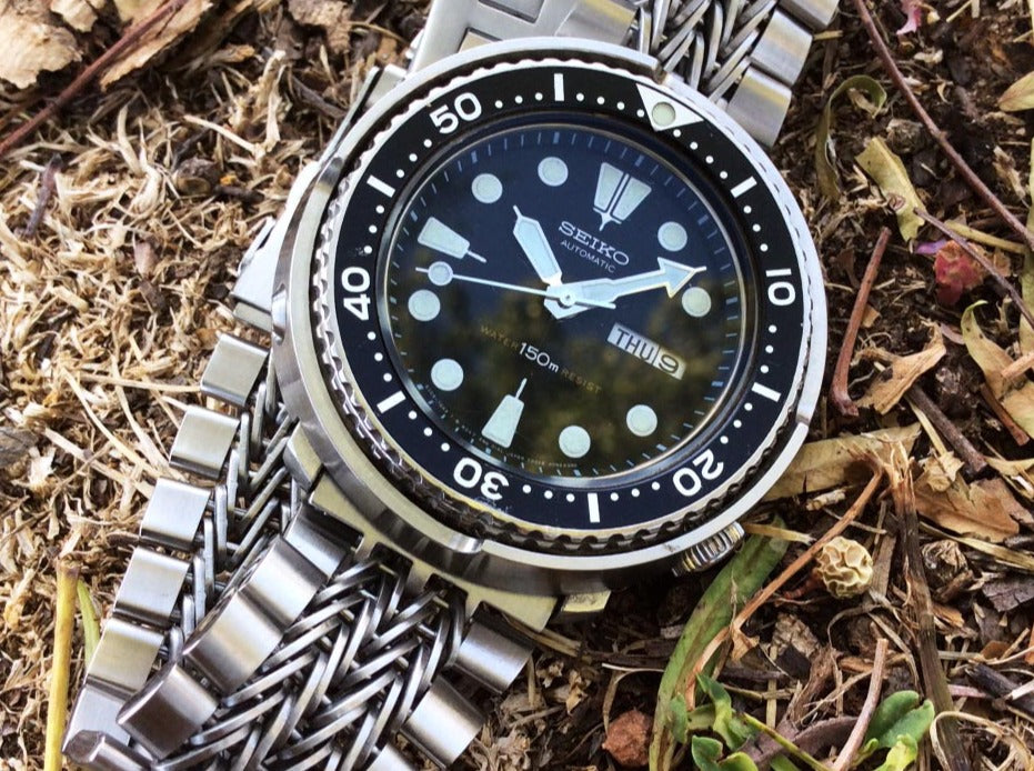 Seiko dive watch with stainless steel razor-wire straight end bracelet on outdoor ground