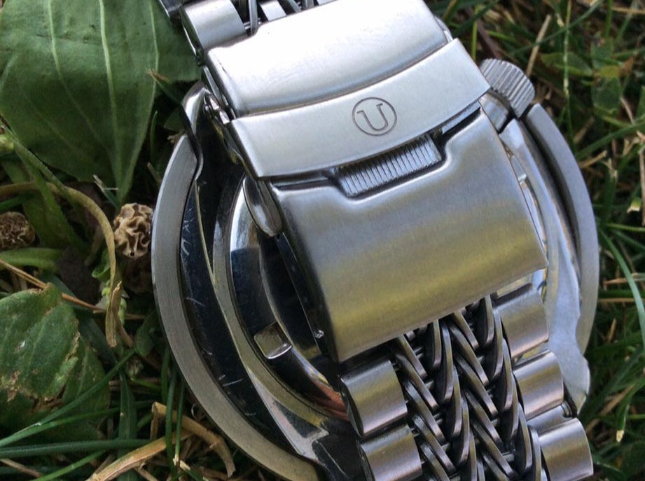 Silver stainless steel bracelet with razor-wire straight end design, 20/22mm width, displayed on grass outdoors