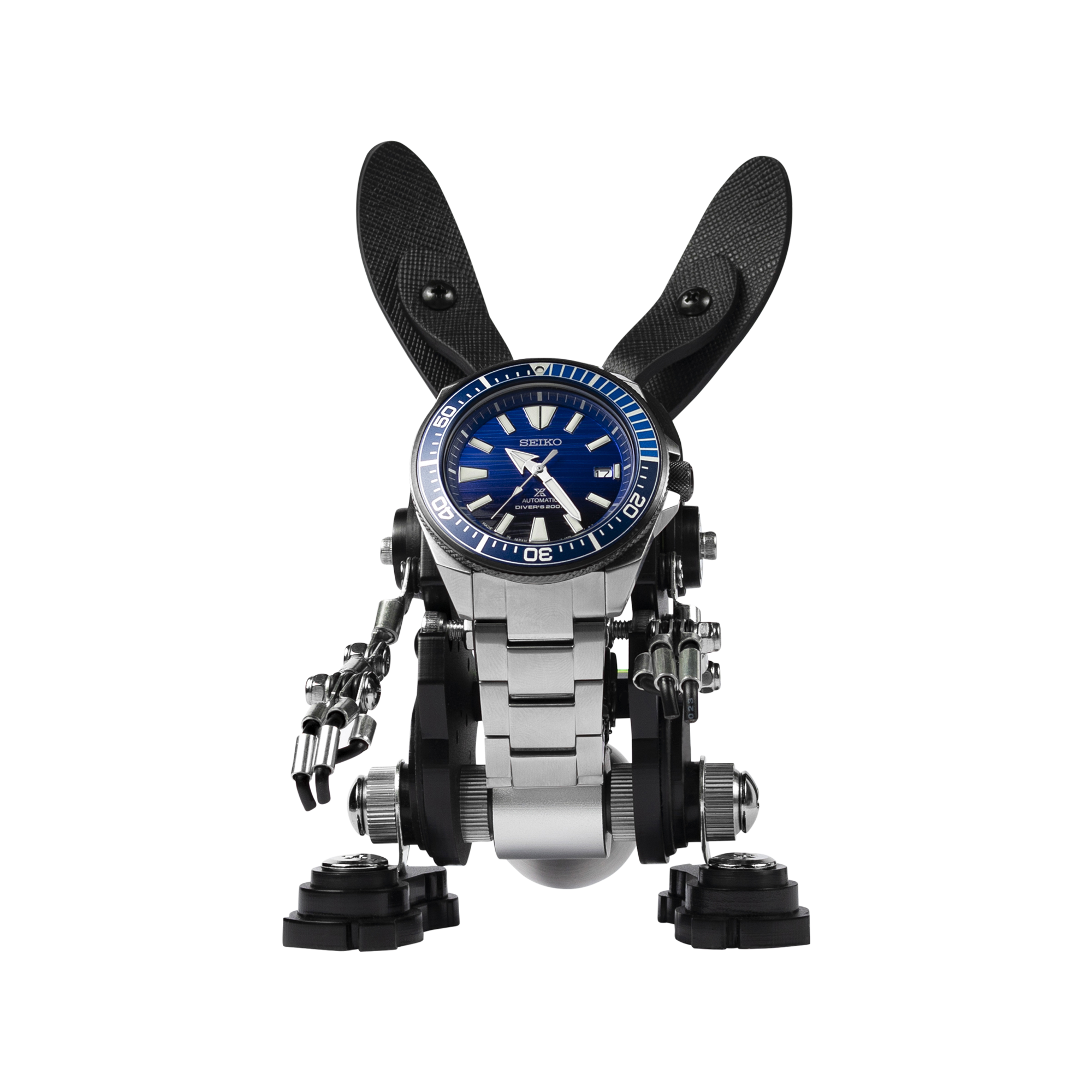 Black RoboRabbit watch stand with blue Seiko dive watch face, articulated metal arms and legs, collectible desk display toy