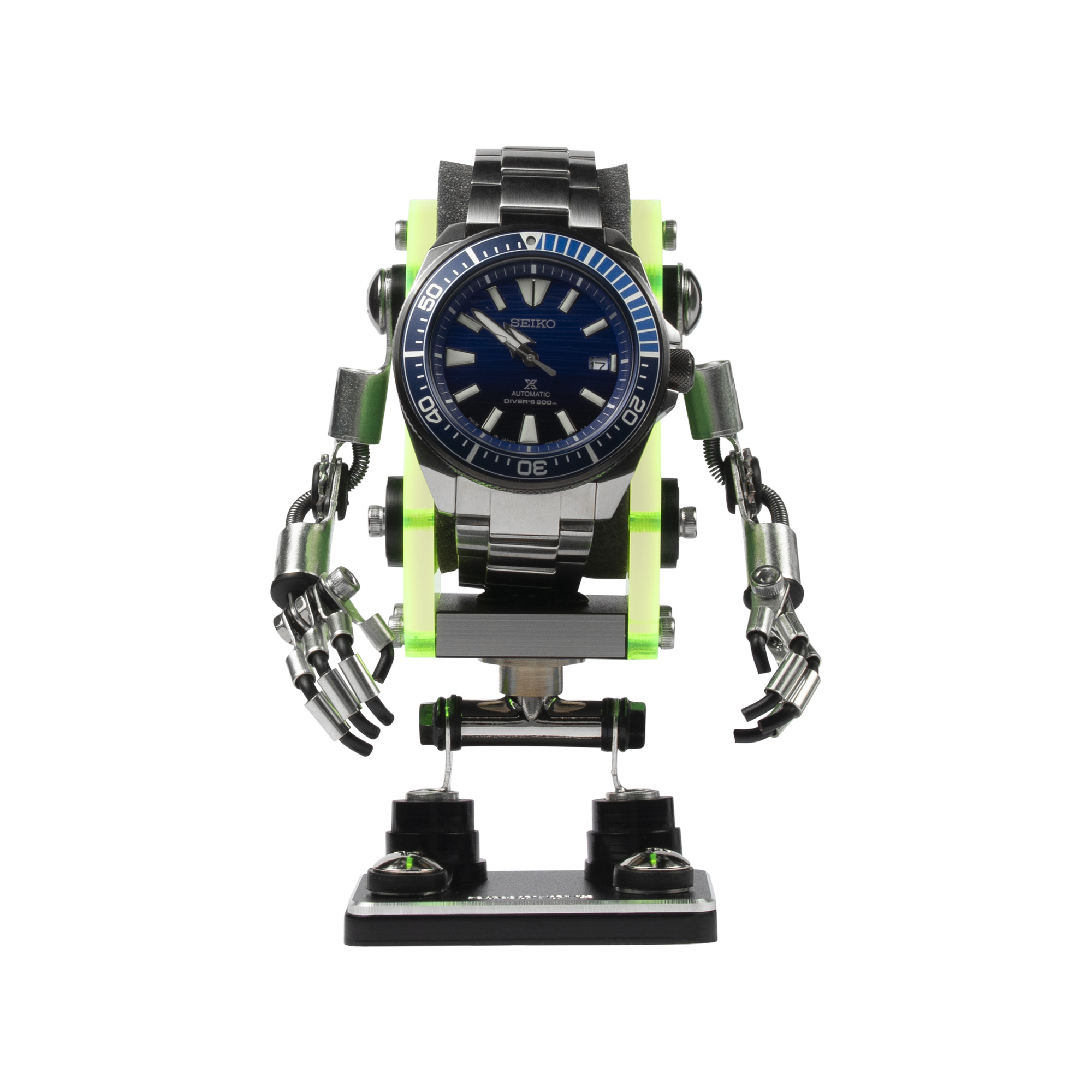 Neon green and black minibot watch stand displaying Seiko automatic dive watch with articulated arms and legs
