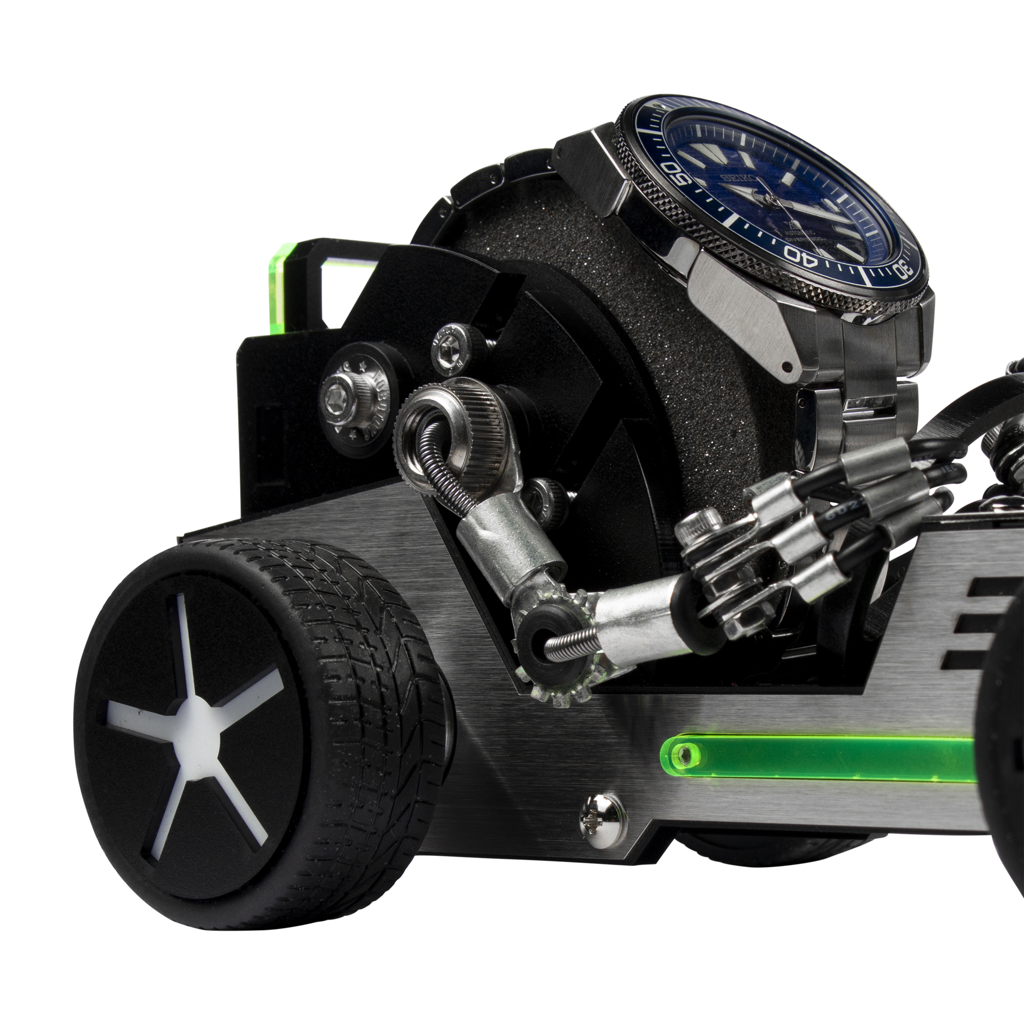 Black metal watch stand shaped like a roadster car with exposed engine, detailed wheels, and green accents