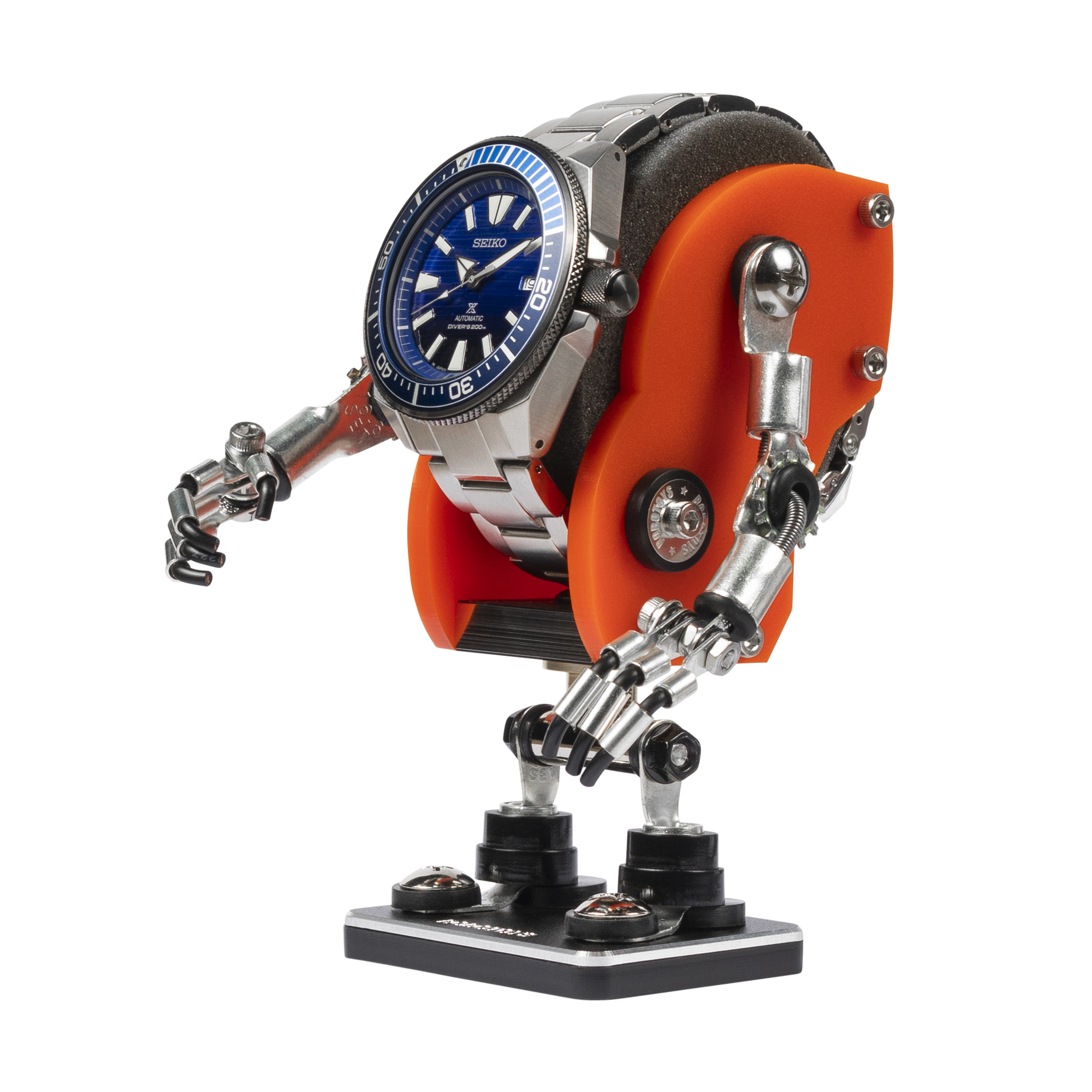 Orange mechanical robot watch stand with articulated silver metal arms and legs holding Seiko automatic diving watch