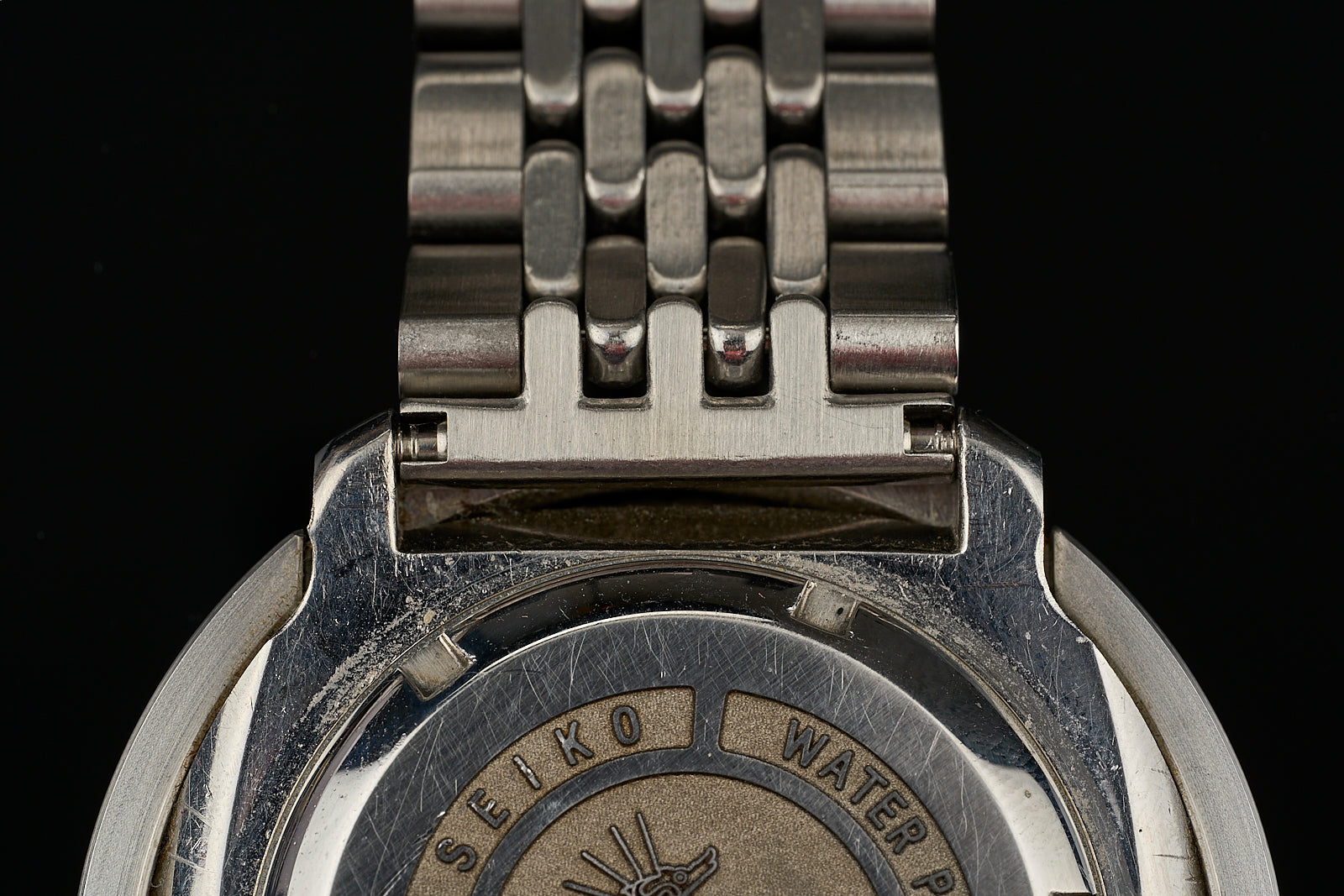 Stainless steel beads of rice link bracelet showing detailed metal construction and seiko water resistant case back