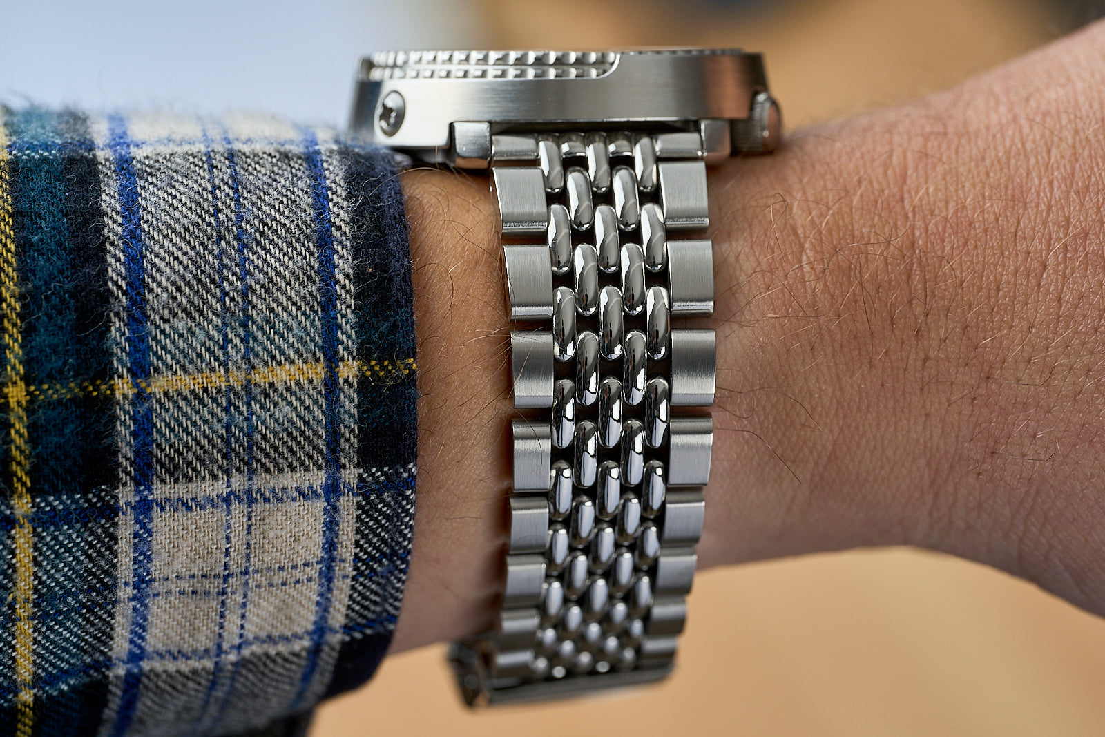 Stainless steel beads of rice bracelet with straight end links worn on wrist with blue plaid shirt cuff
