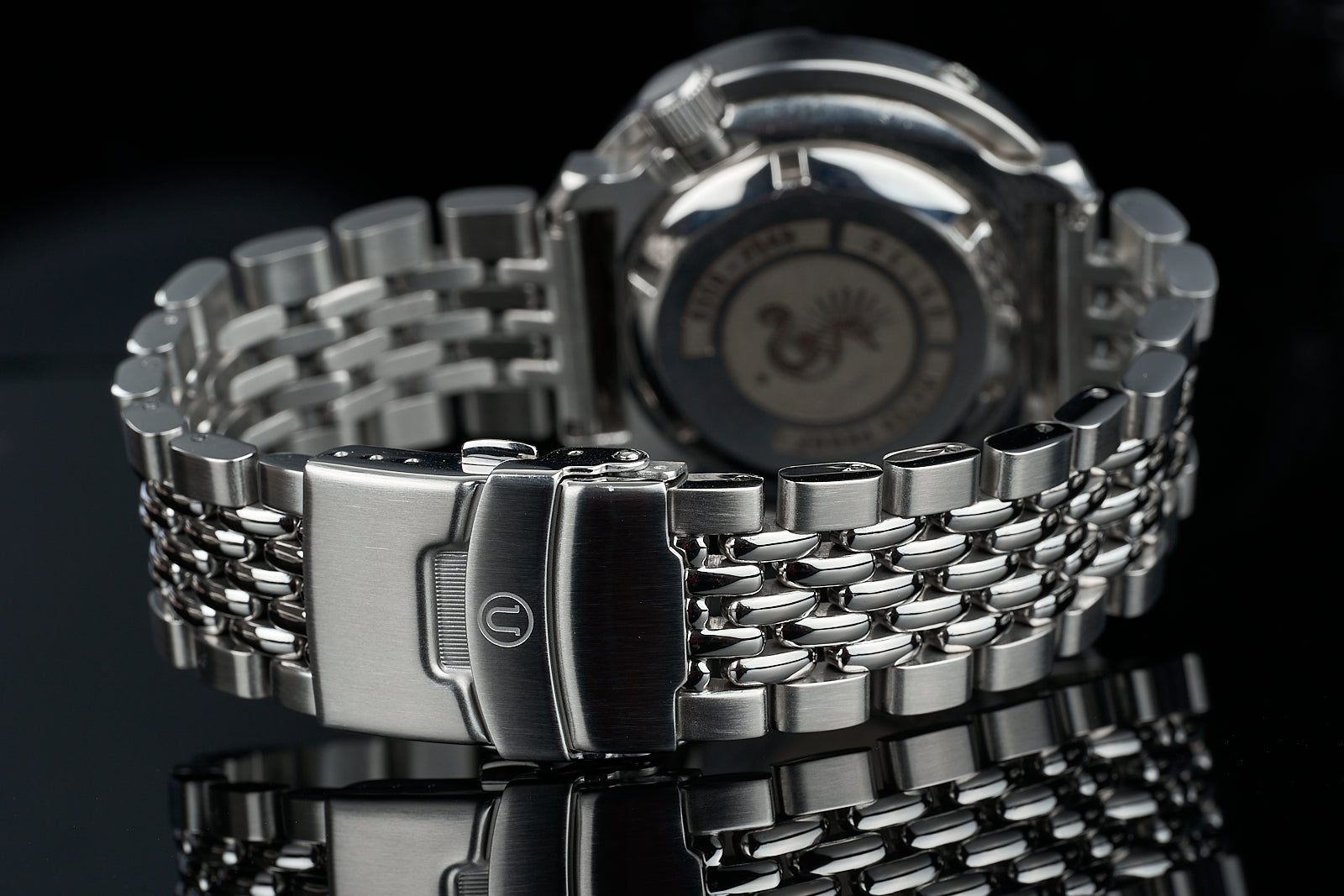 Stainless steel beads of rice bracelet with fold-over clasp, 18-22mm width, displayed with matching watch on black background