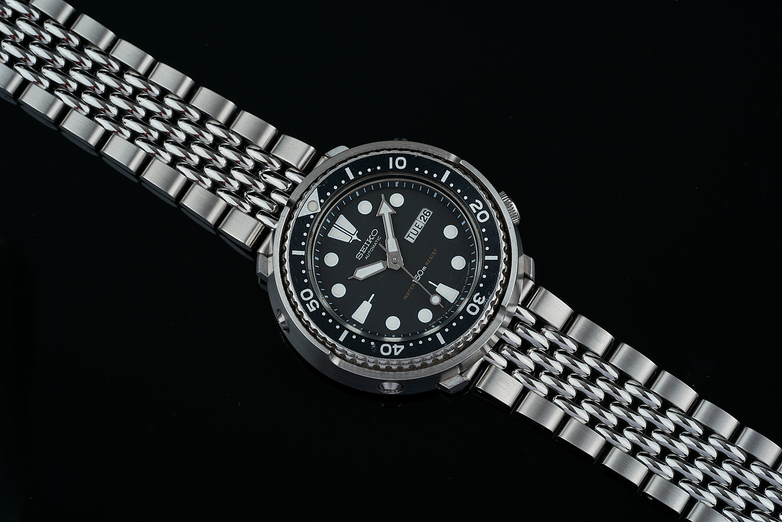 Stainless steel diving watch with black dial, white hour markers, date window, and matching beads of rice metal bracelet