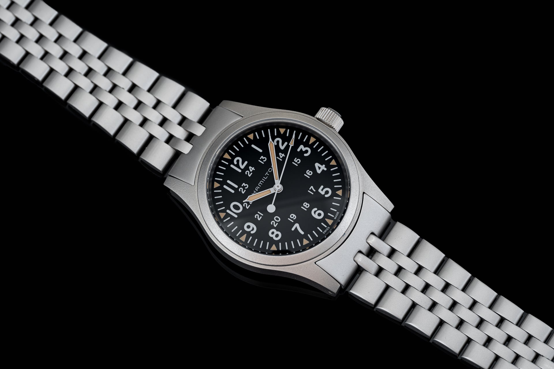 Stainless steel mechanical watch with black dial, Arabic numerals, and matching metal bracelet on black background