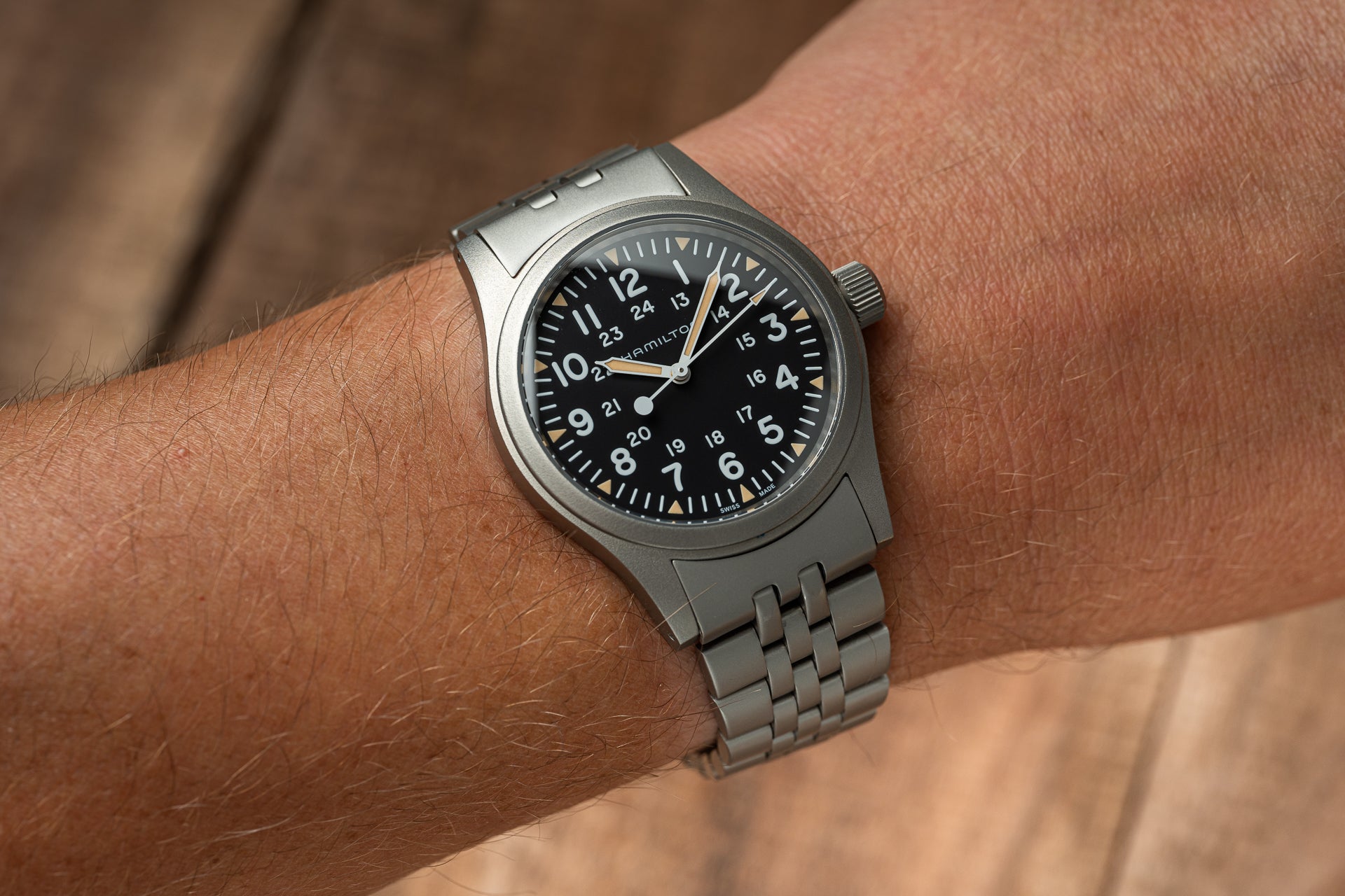 Hamilton Khaki mechanical watch with black dial and 24-hour markings on stainless steel bracelet worn on wrist