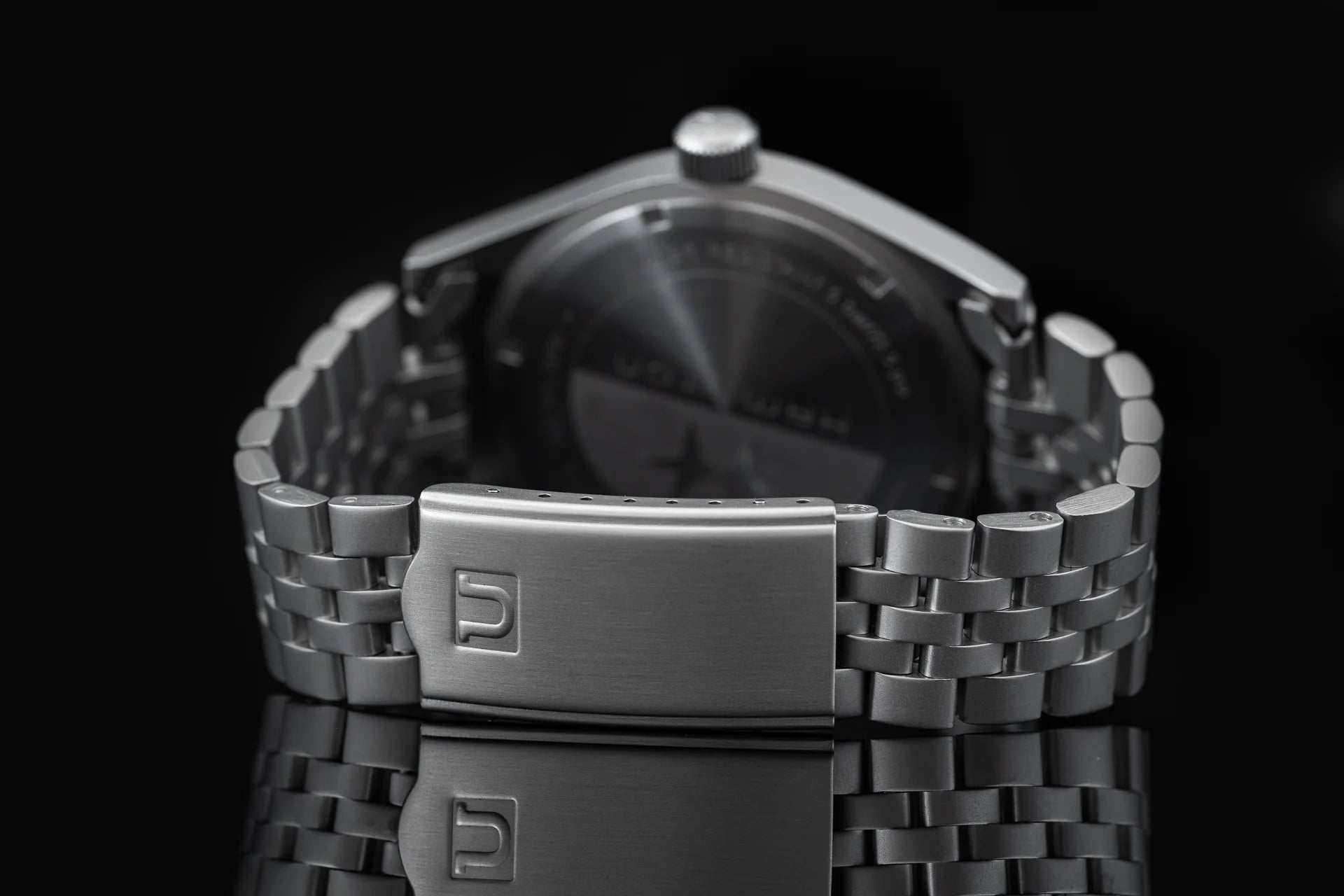 Stainless steel link bracelet with brushed metal clasp for Hamilton Khaki mechanical watch, rear view against black background
