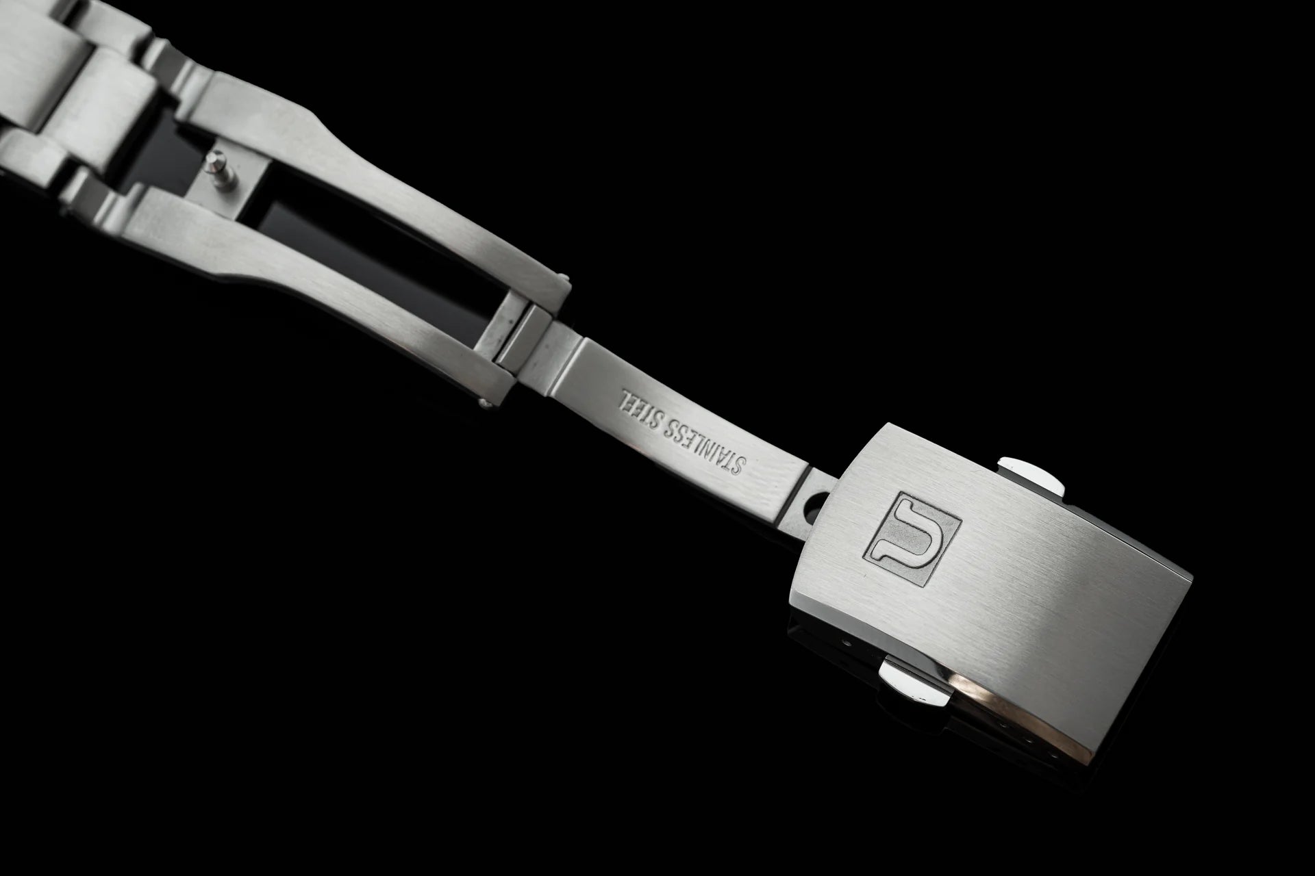 Stainless steel tactical bracelet with numbered buckle and adjustable webbing band on black background