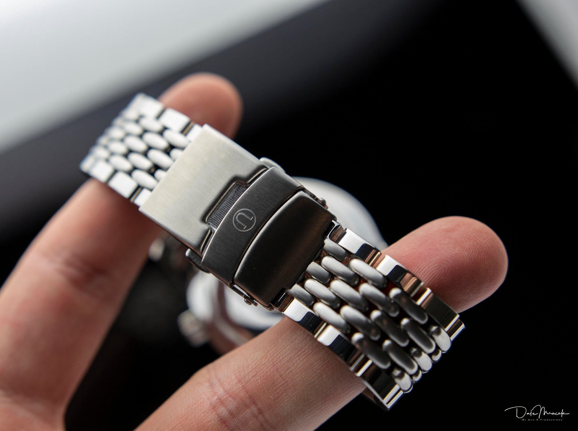 Stainless steel beads of rice bracelet with black center link for Longines Legend watch, held in hand
