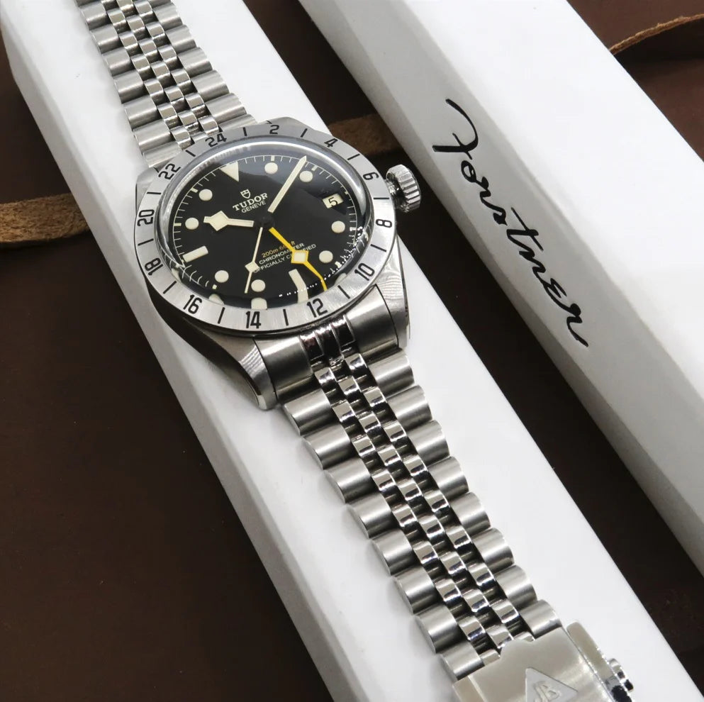 Tudor Black Bay Pro stainless steel watch with black dial, yellow hand, and GMT bezel on jubilee bracelet