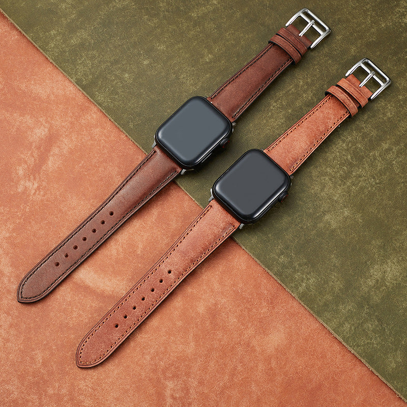 Tan and cognac leather smartwatch bands with silver buckles for Apple Watch, displayed on color-blocked tan and sage background