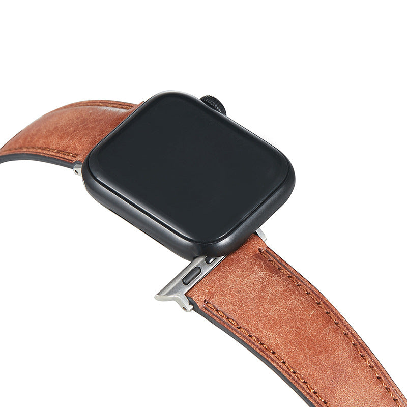Black smartwatch with cognac brown leather band and silver connector clasp on white background