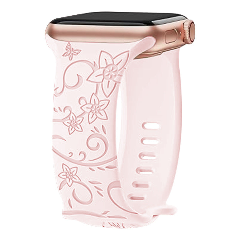Pink floral silicone band with ornate flower design for Apple Watch, rose gold aluminum case visible at top