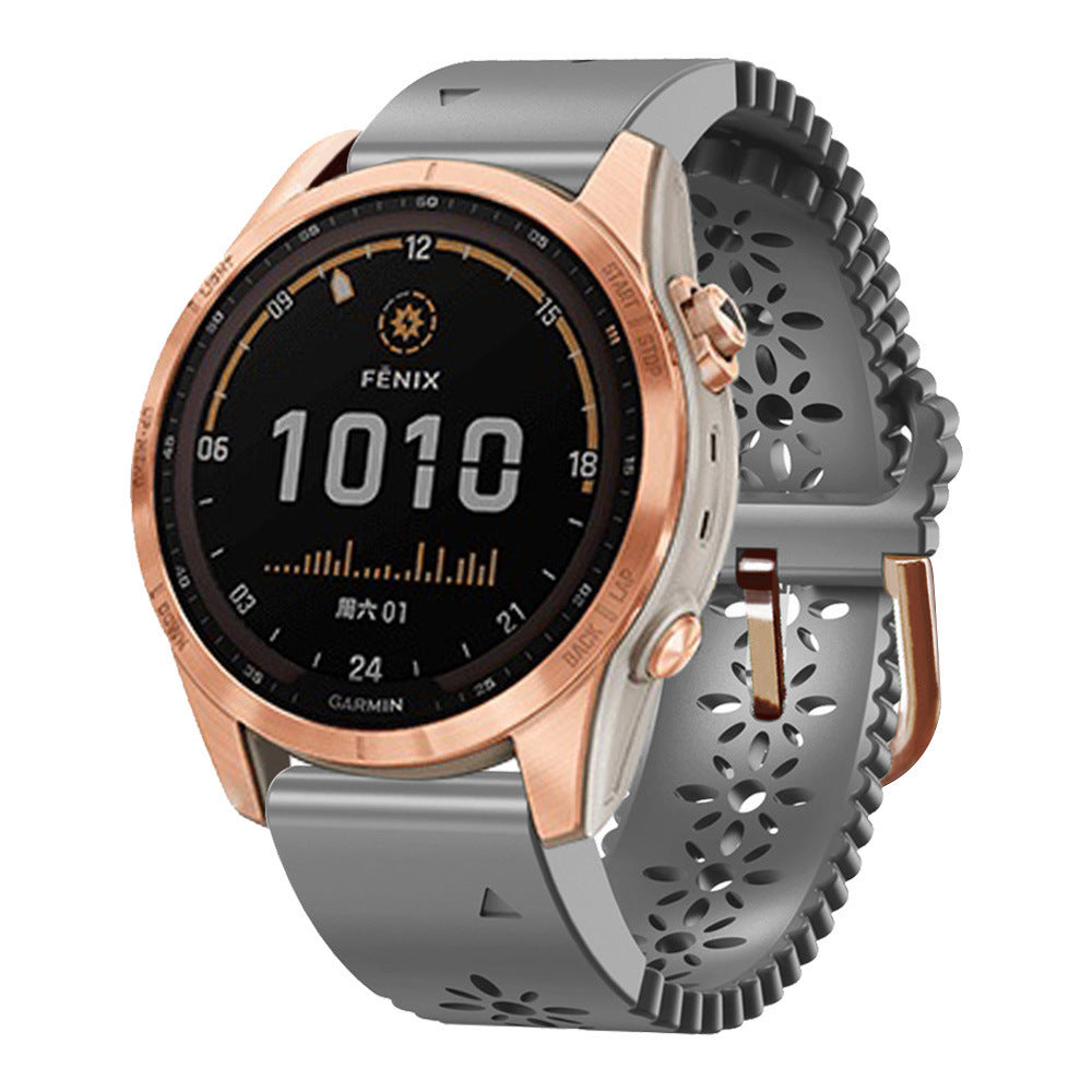 Garmin Fenix smartwatch with rose gold bezel, gray silicone QuickFit band, black digital display showing time 10:10
