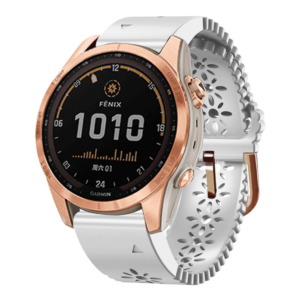 Garmin Fenix smartwatch with rose gold case, white silicone floral strap, and black digital display showing time 10:10