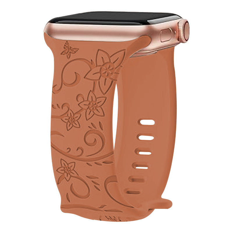 Tan silicone Apple Watch band with embossed floral vine pattern and adjustable vent holes