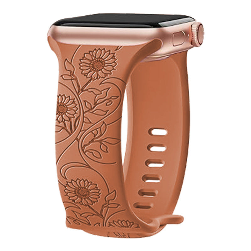 Tan silicone Apple Watch band with embossed floral sunflower design and adjustable strap holes