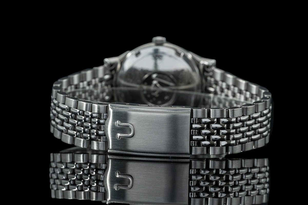 Stainless steel beads of rice bracelet with fold-over clasp for Omega Constellation watch, detailed metal links on black background